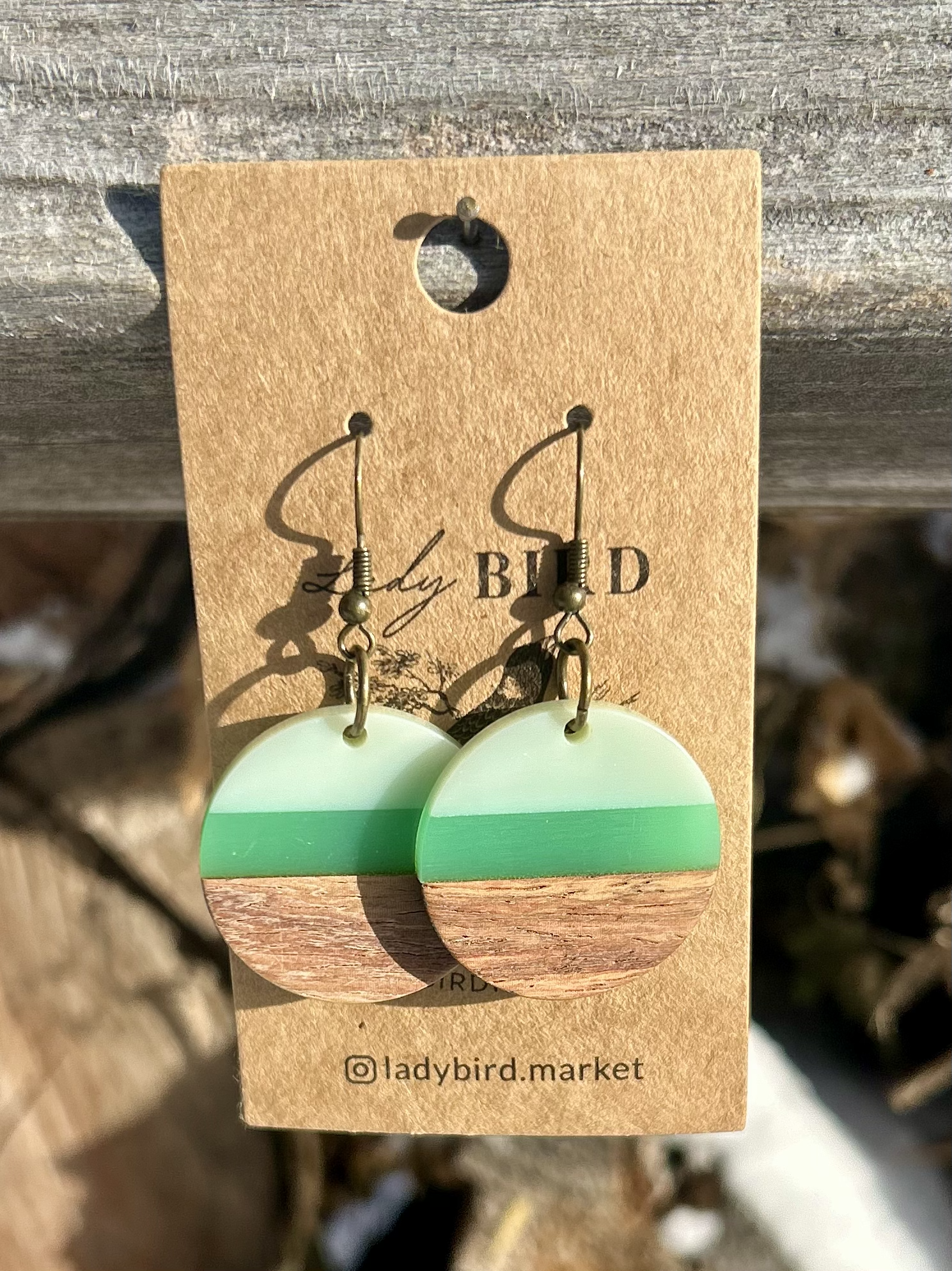 A pair of Walnut Wood and Lime Green Striped Resin Circle Earrings showcasing unique wood grain and vibrant green stripes.