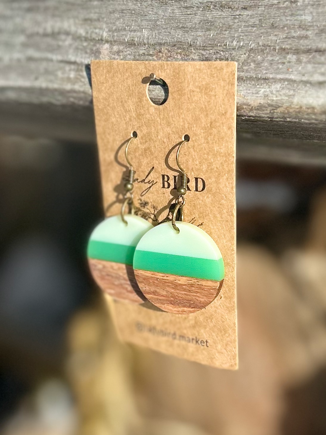 A pair of Walnut Wood and Lime Green Striped Resin Circle Earrings showcasing unique wood grain and vibrant green stripes.