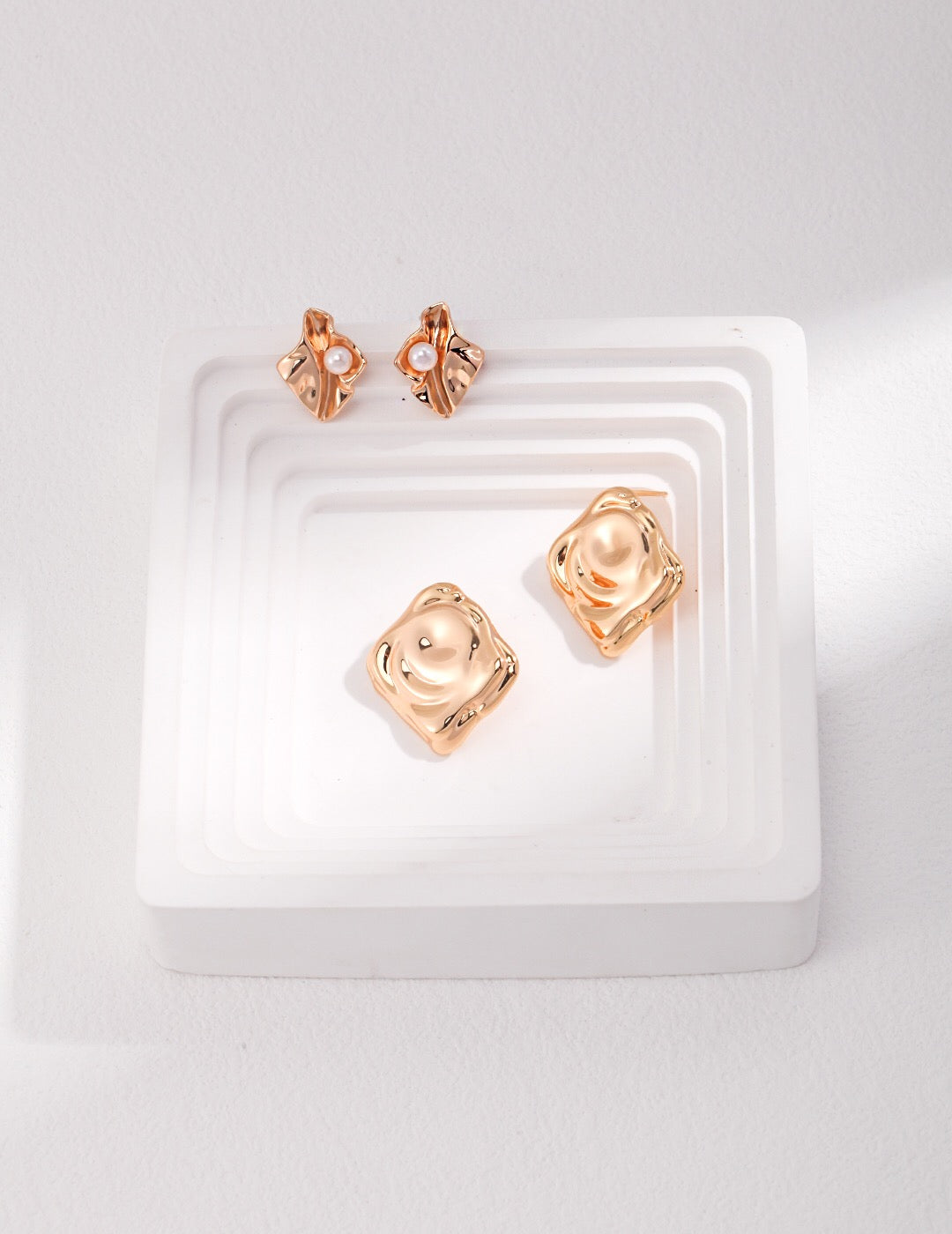 Elegant Wave Geometric Pearl Stud Earrings made of mother of pearl and gold vermeil, showcasing a unique design.