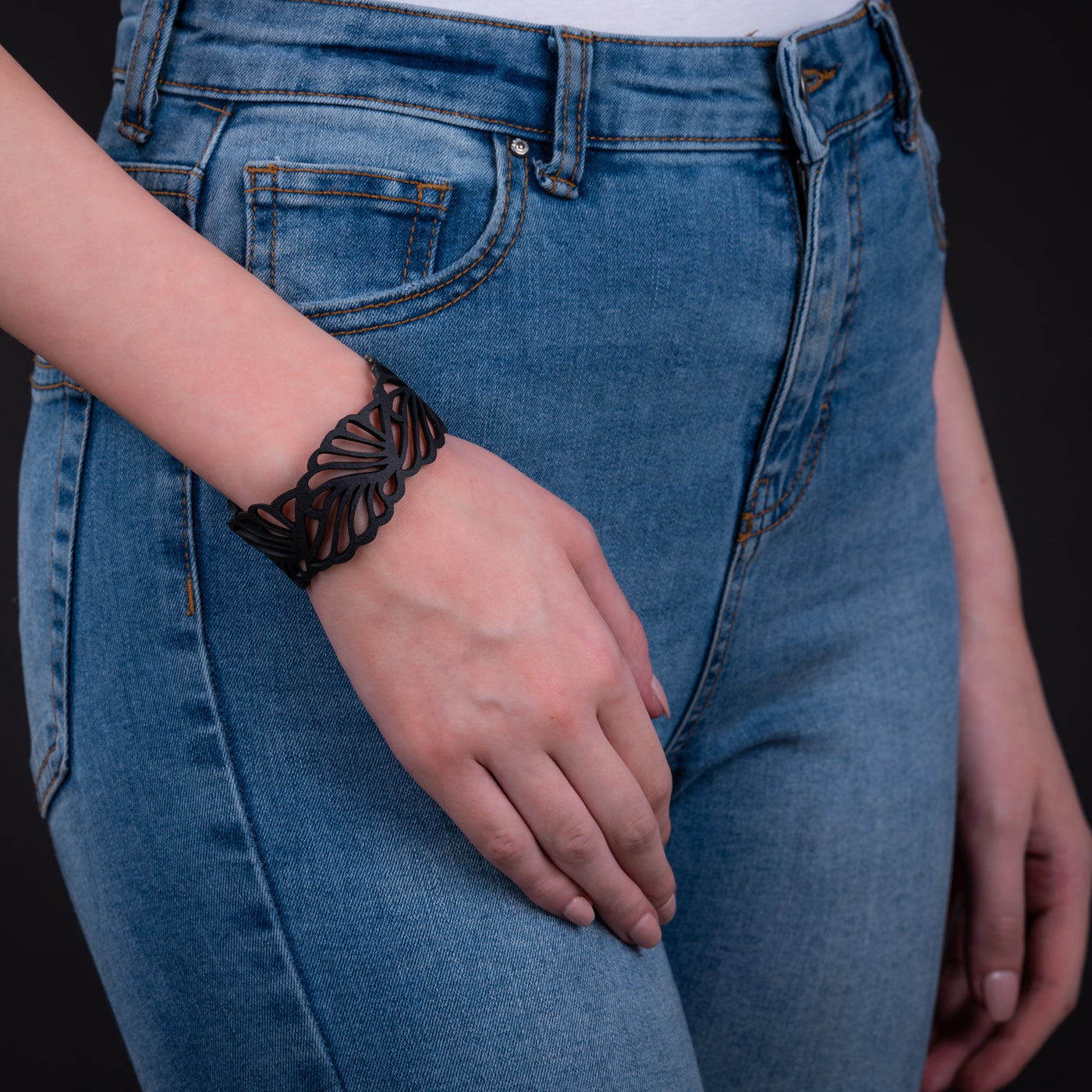 A stylish Weave Recycled Inner Tube Bracelet made from reclaimed rubber, showcasing intricate hand-woven patterns and a plastic button clasp.