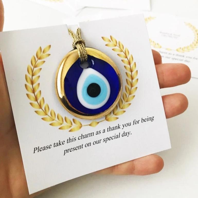 Handmade blue glass evil eye bead wedding favors with personalized cards, symbolizing good luck and protection.