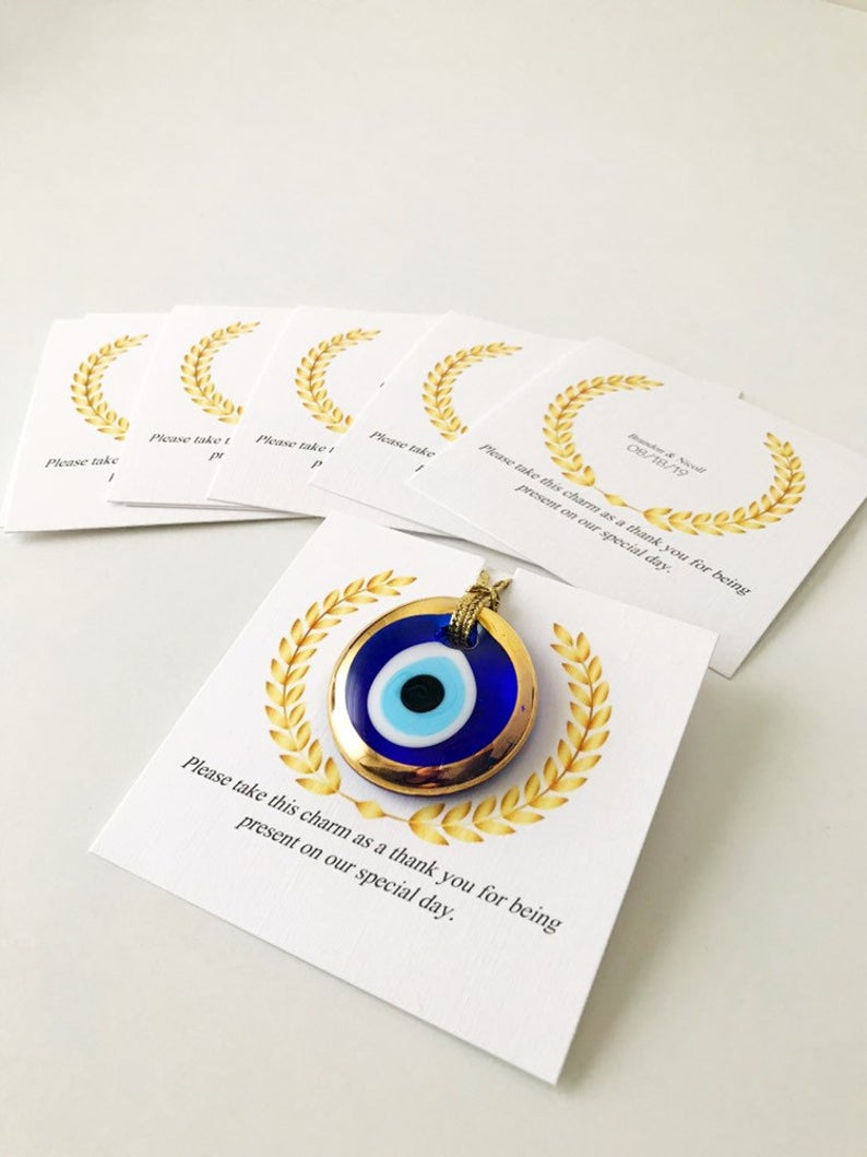 Handmade blue glass evil eye bead wedding favors with personalized cards, symbolizing good luck and protection.