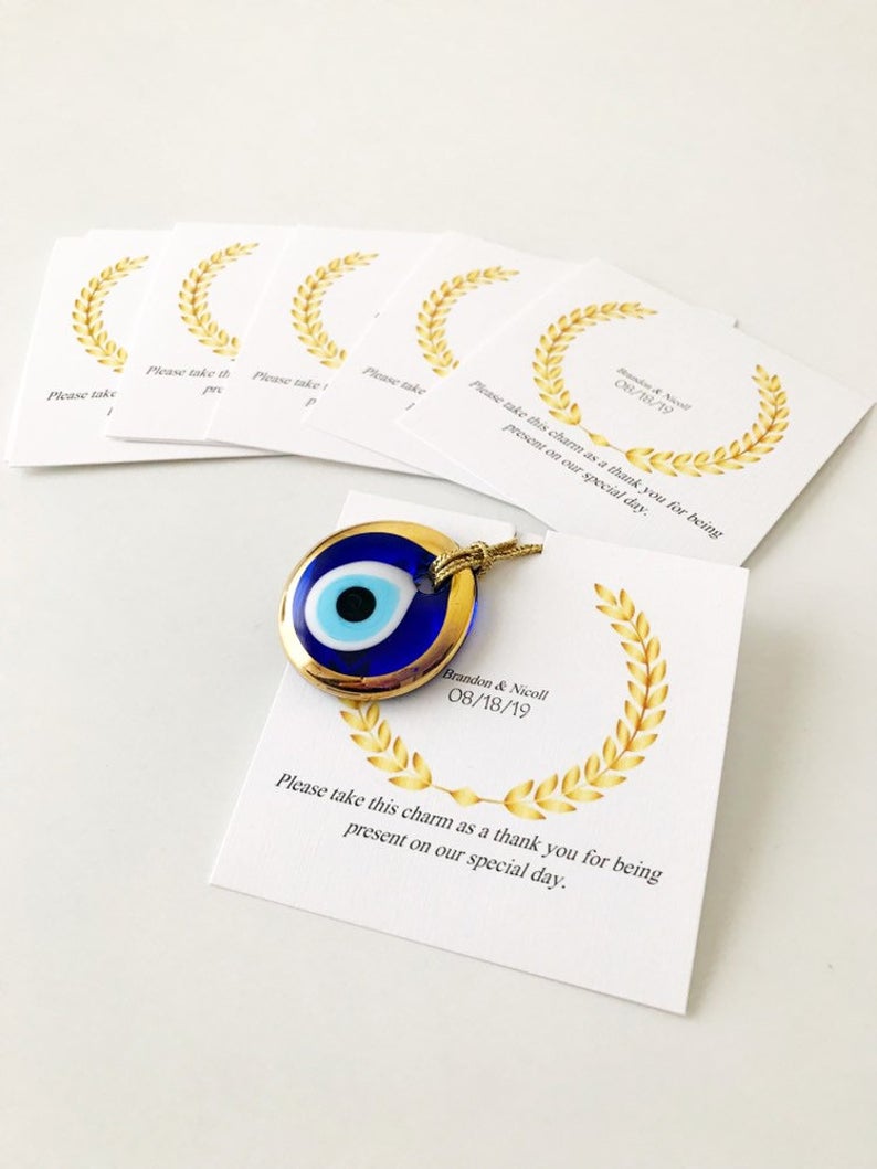 Handmade blue glass evil eye bead wedding favors with personalized cards, symbolizing good luck and protection.