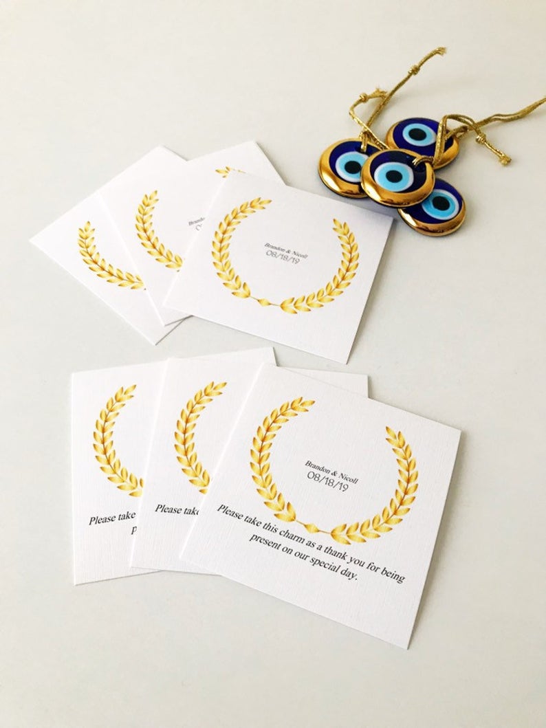 Handmade blue glass evil eye bead wedding favors with personalized cards, symbolizing good luck and protection.