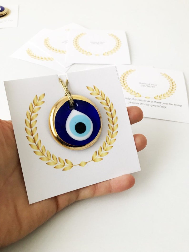 Handmade blue glass evil eye bead wedding favors with personalized cards, symbolizing good luck and protection.