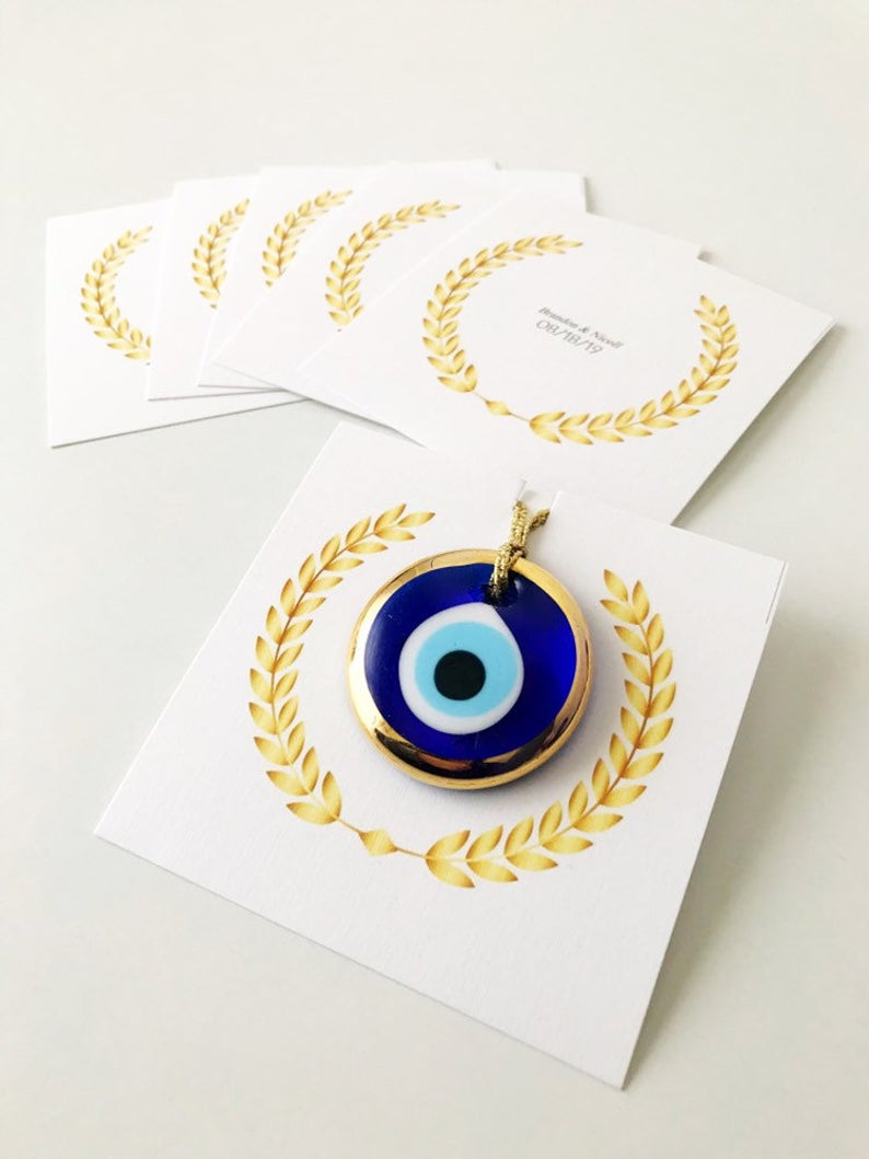 Handmade blue glass evil eye bead wedding favors with personalized cards, symbolizing good luck and protection.