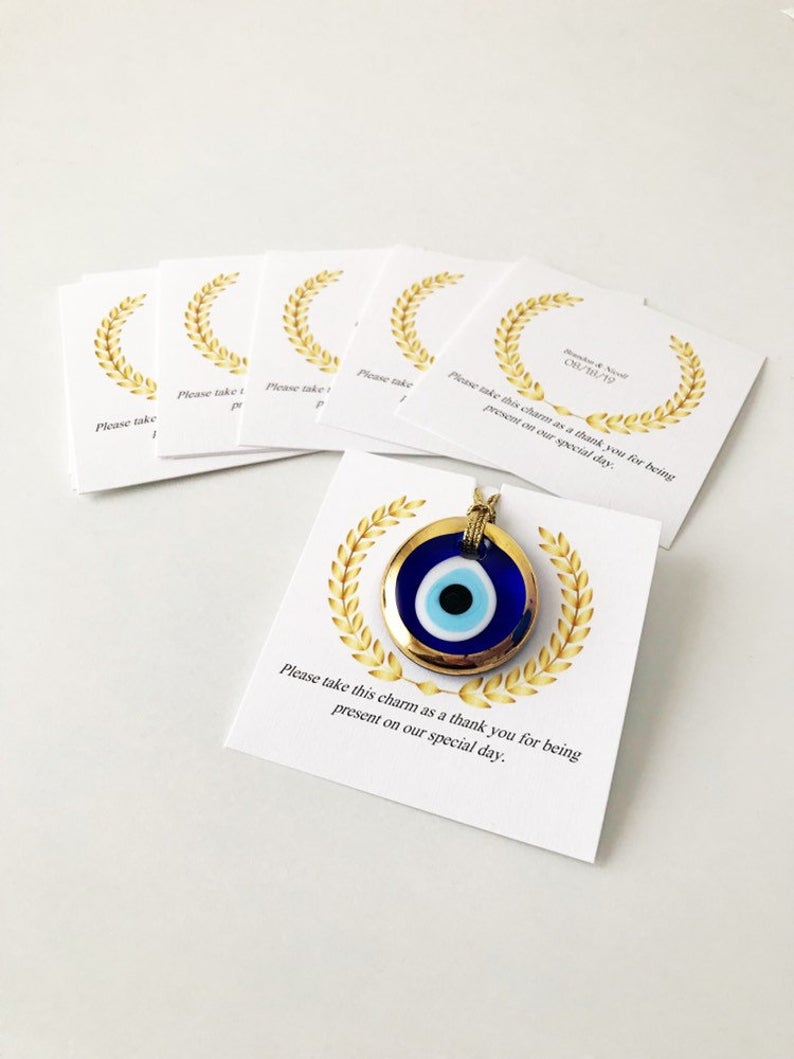 Handmade blue glass evil eye bead wedding favors with personalized cards, symbolizing good luck and protection.