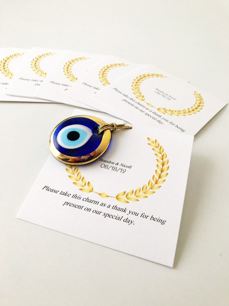 Handmade blue glass evil eye bead wedding favors with personalized cards, symbolizing good luck and protection.