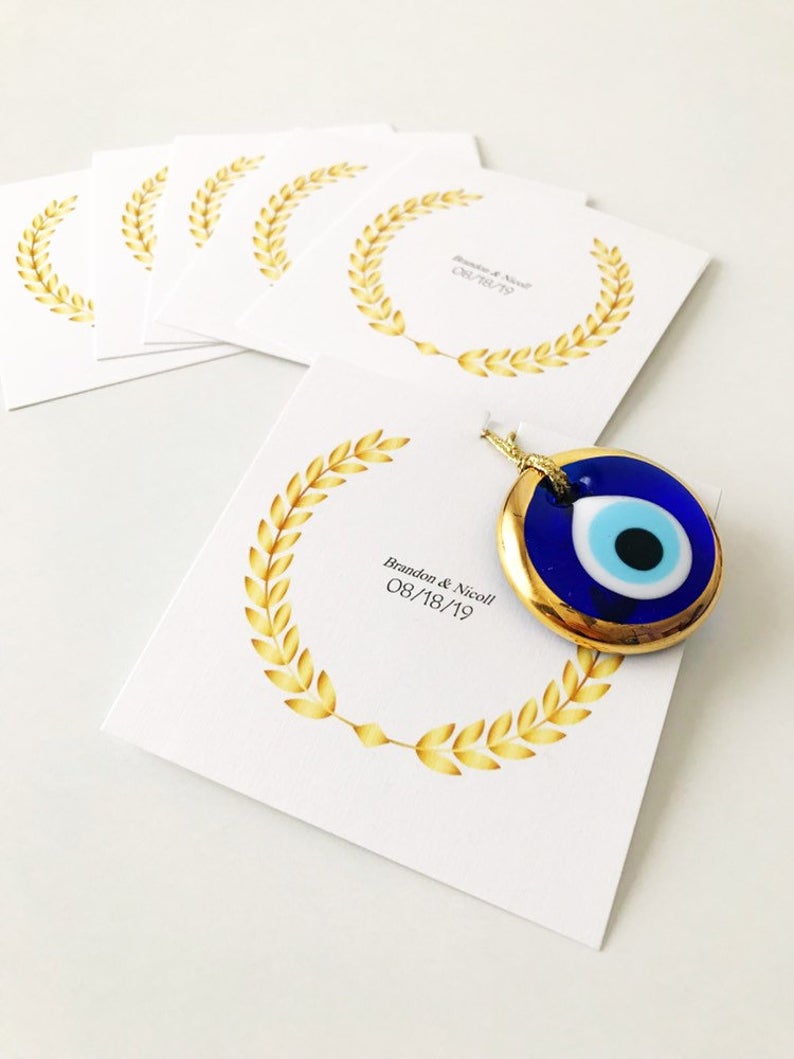 Handmade blue glass evil eye bead wedding favors with personalized cards, symbolizing good luck and protection.