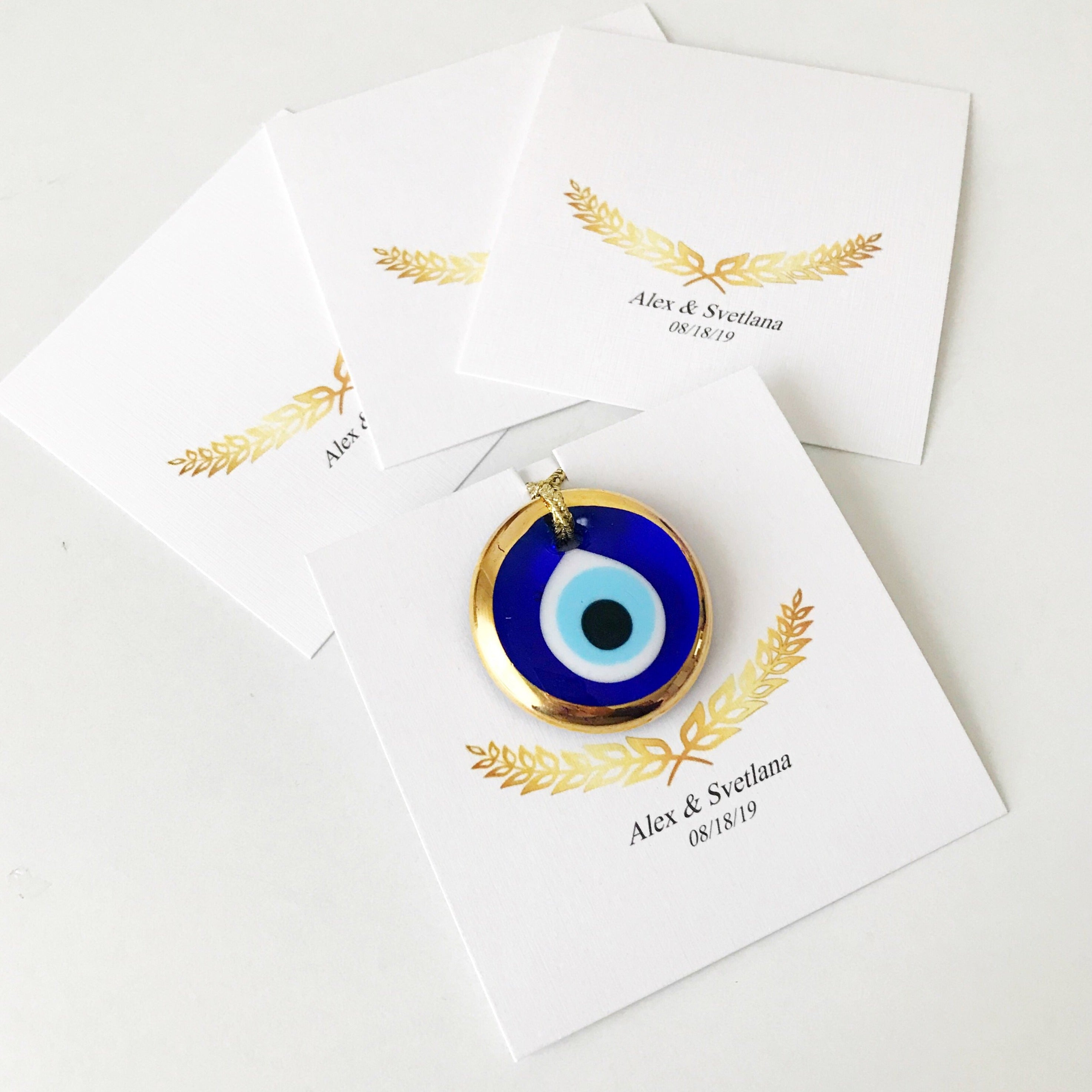 Elegant gold evil eye beads designed for wedding favors, featuring personalized cards and a charming design.