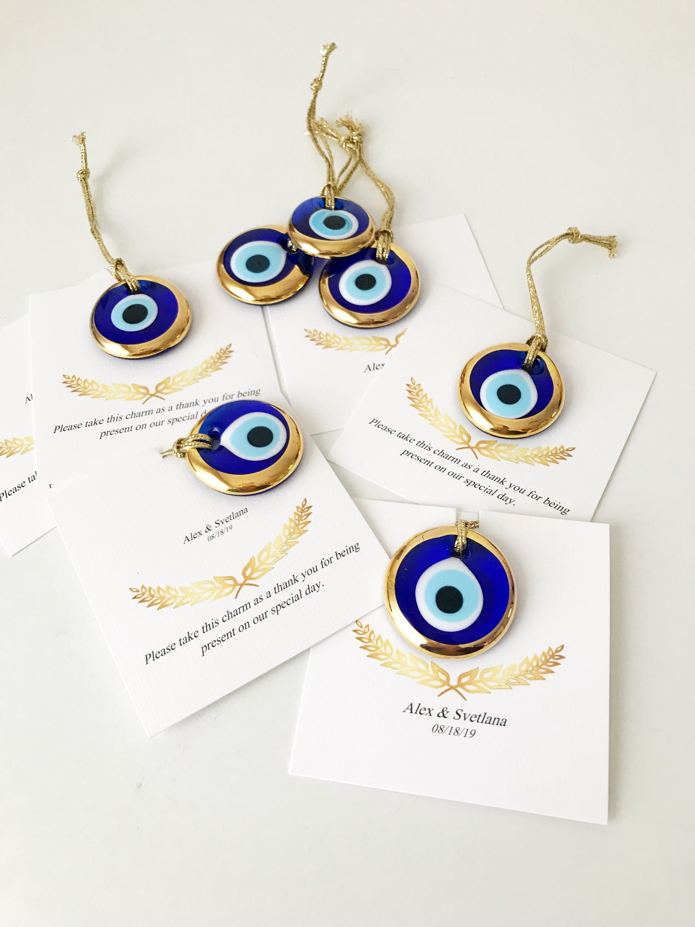 Elegant gold evil eye beads designed for wedding favors, featuring personalized cards and a charming design.