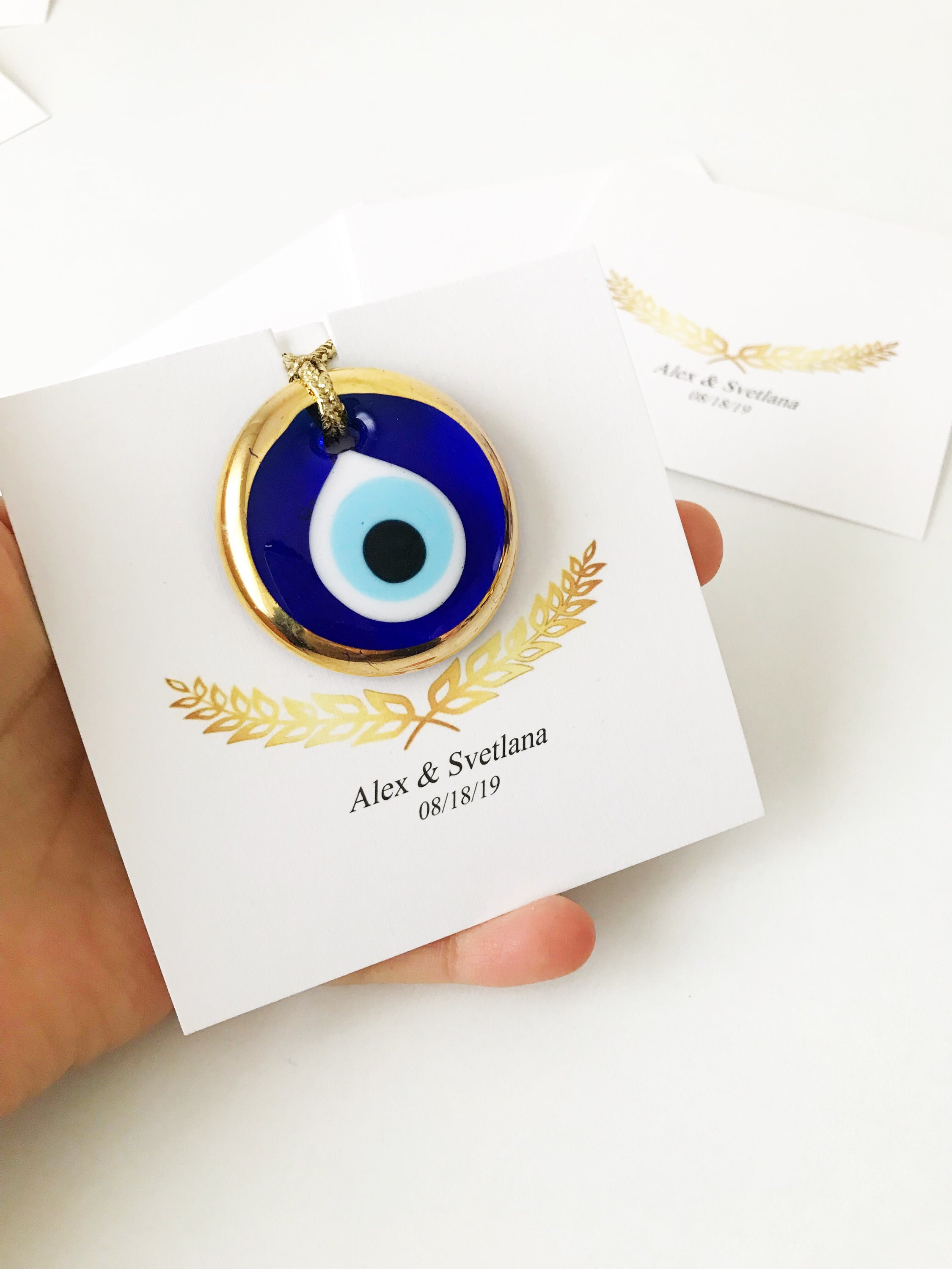 Elegant gold evil eye beads designed for wedding favors, featuring personalized cards and a charming design.