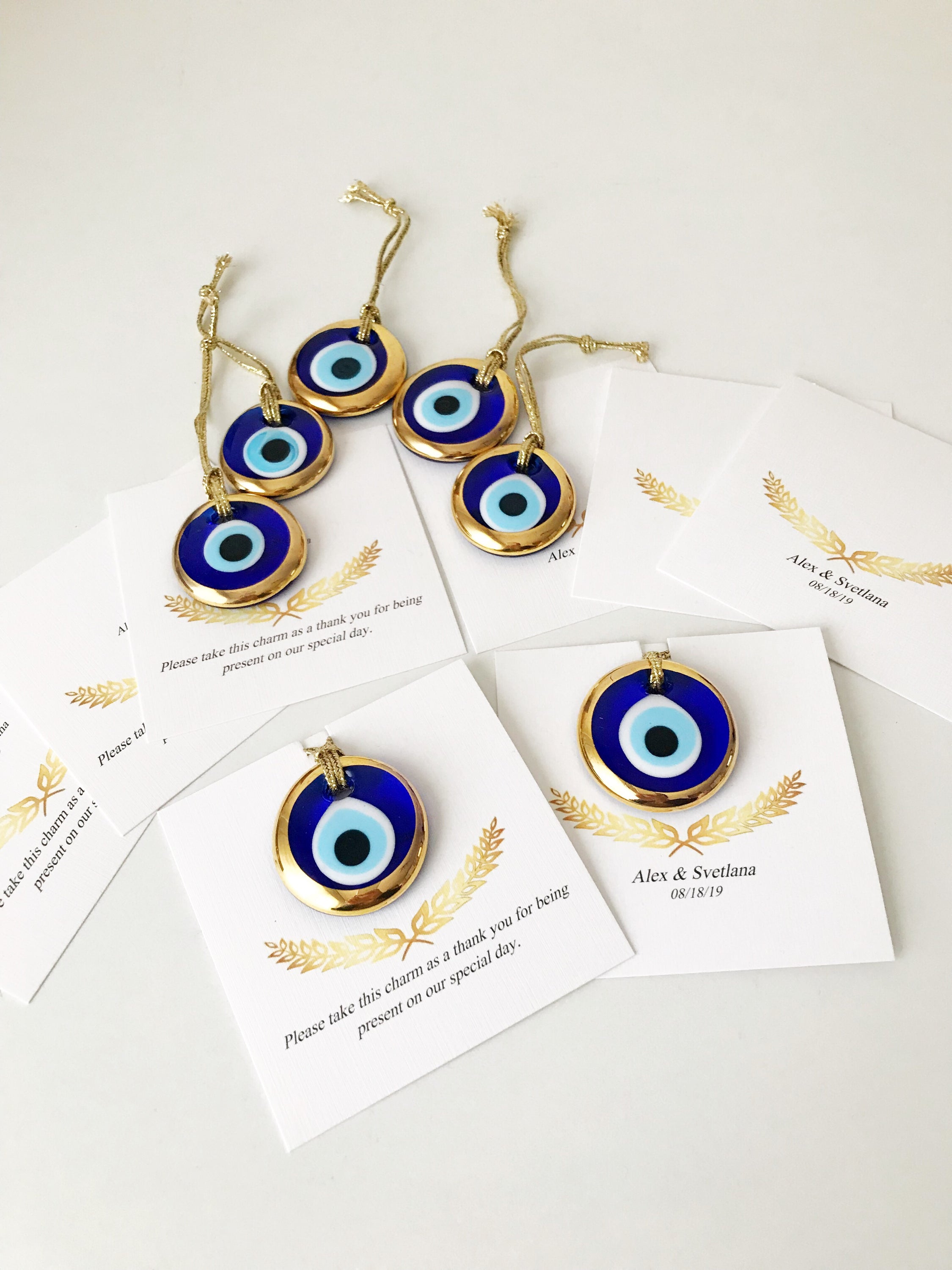 Elegant gold evil eye beads designed for wedding favors, featuring personalized cards and a charming design.