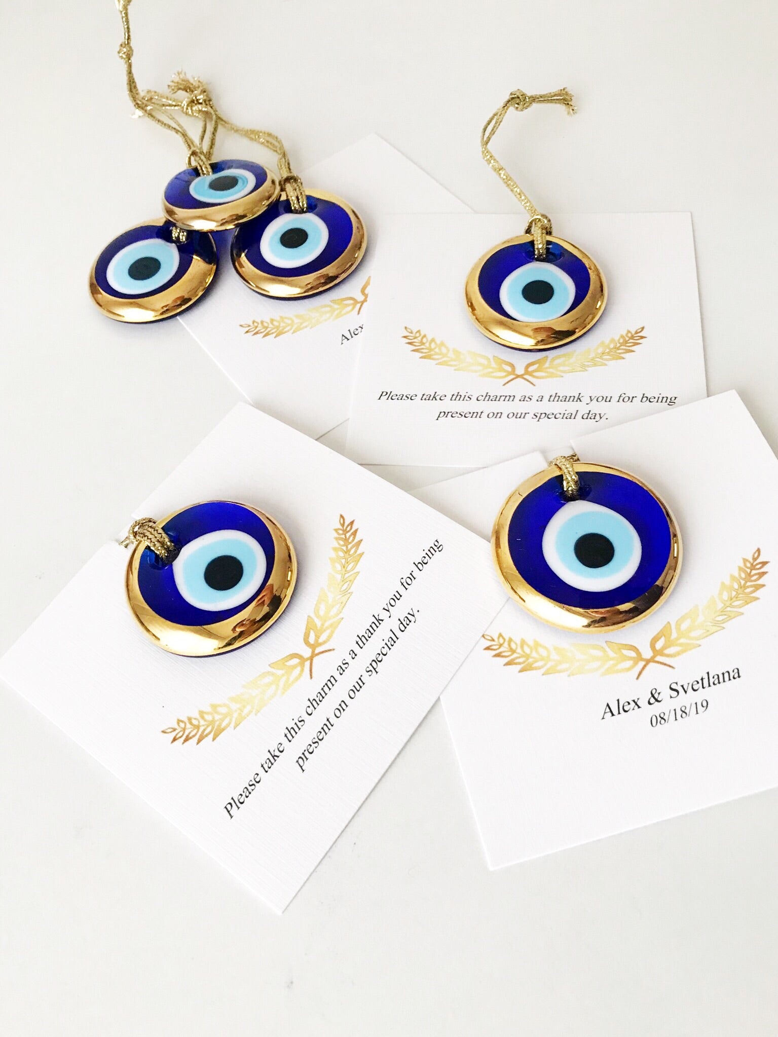 Elegant gold evil eye beads designed for wedding favors, featuring personalized cards and a charming design.