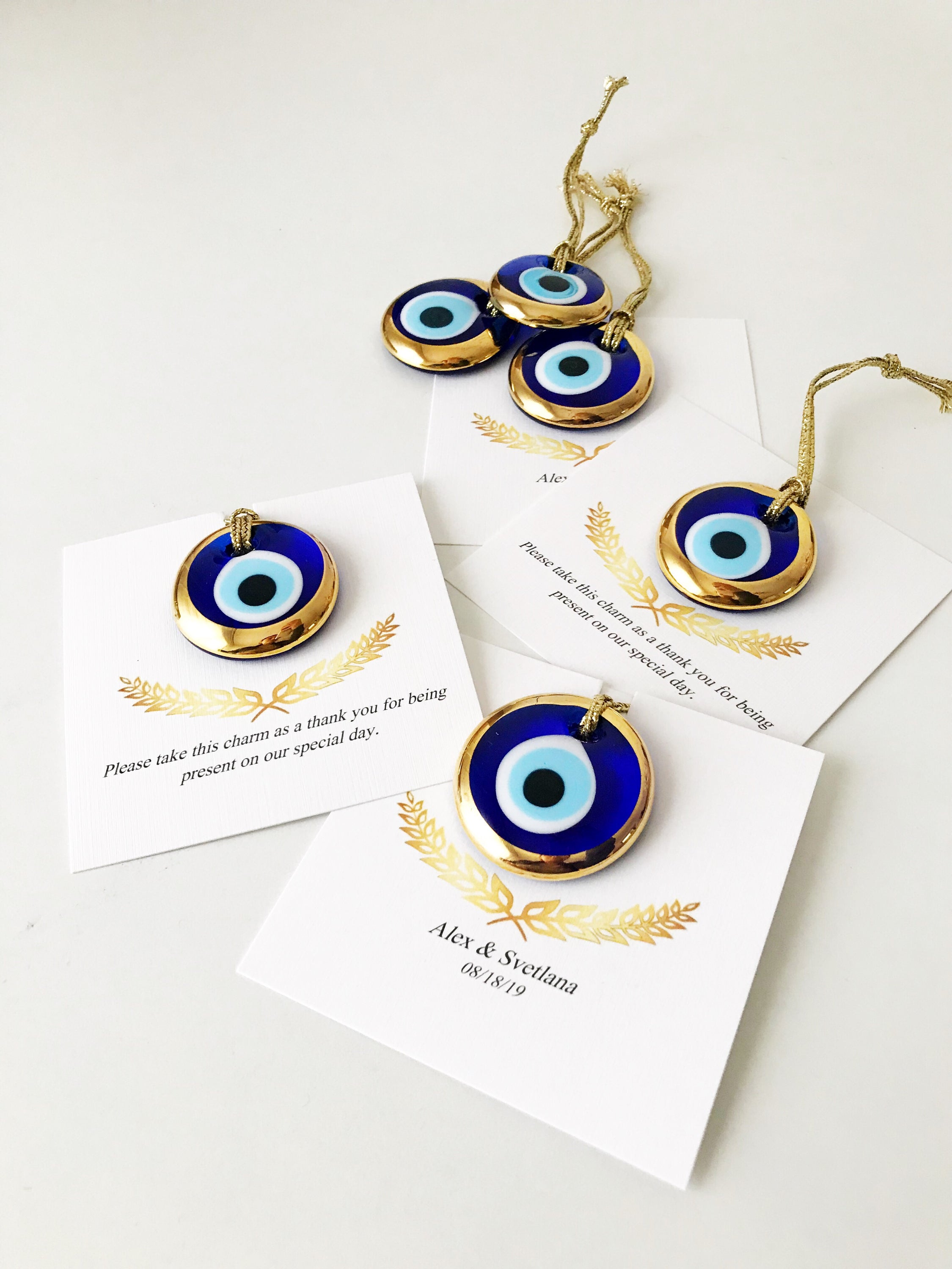 Elegant gold evil eye beads designed for wedding favors, featuring personalized cards and a charming design.