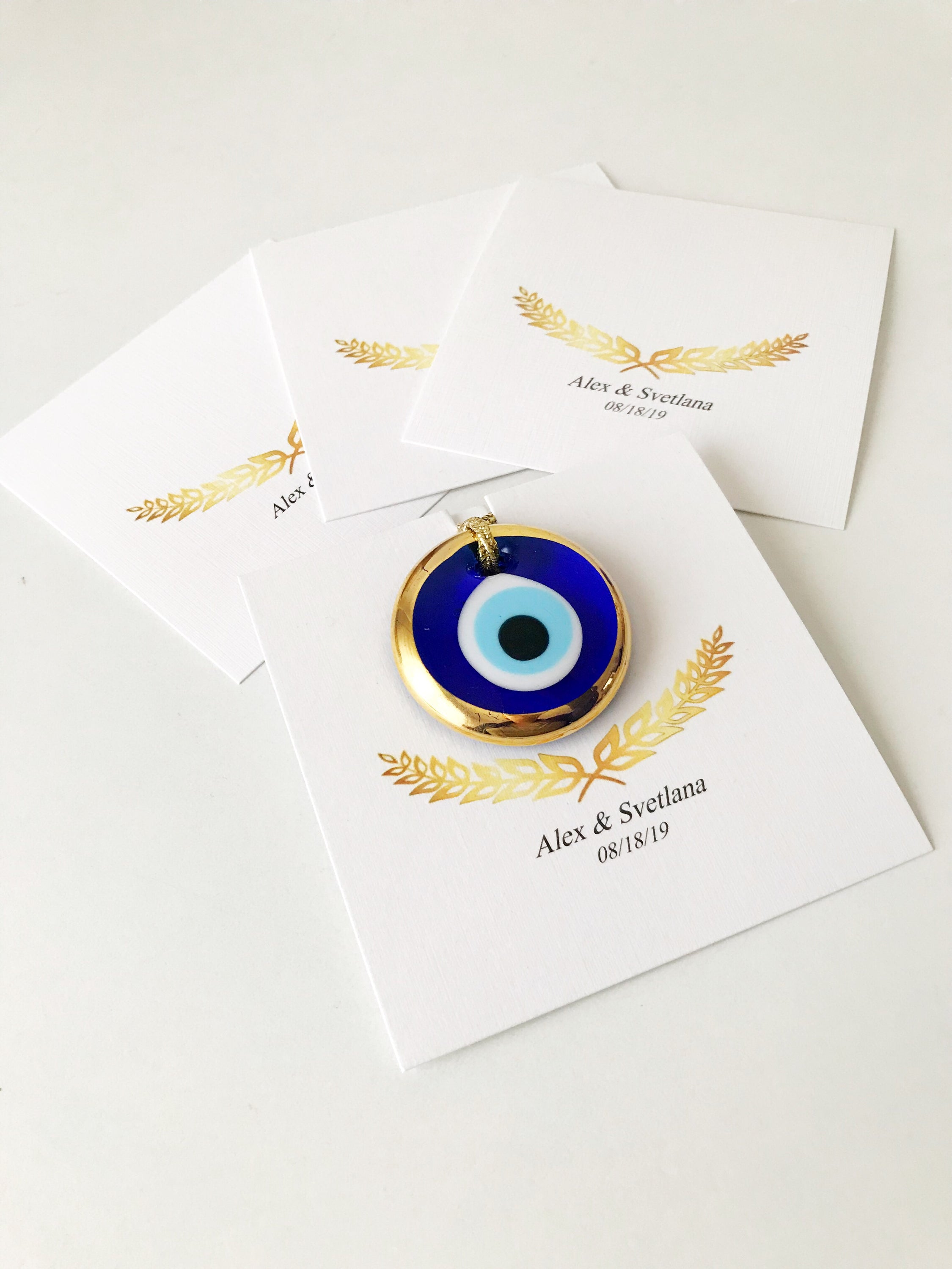 Elegant gold evil eye beads designed for wedding favors, featuring personalized cards and a charming design.