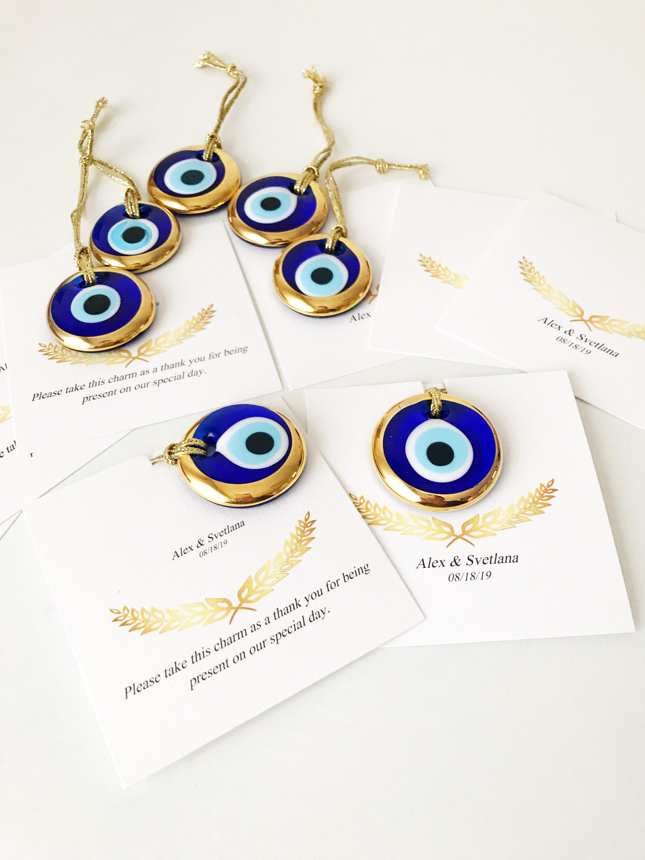 Elegant gold evil eye beads designed for wedding favors, featuring personalized cards and a charming design.