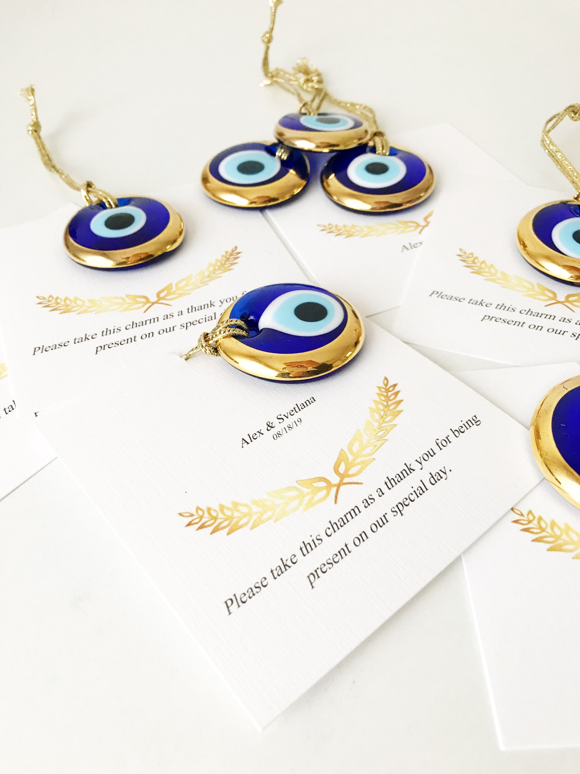 Elegant gold evil eye beads designed for wedding favors, featuring personalized cards and a charming design.