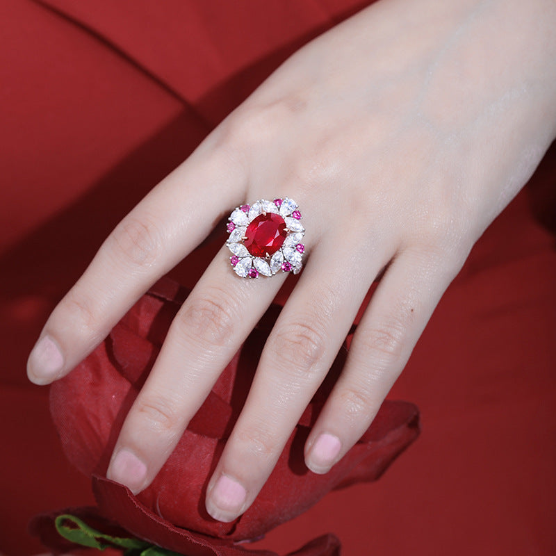 Luxurious ruby engagement ring crafted from 925 sterling silver, featuring a simulated red ruby center stone surrounded by white sapphires and pink accents.