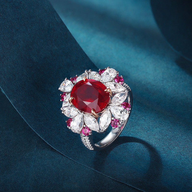 Luxurious ruby engagement ring crafted from 925 sterling silver, featuring a simulated red ruby center stone surrounded by white sapphires and pink accents.