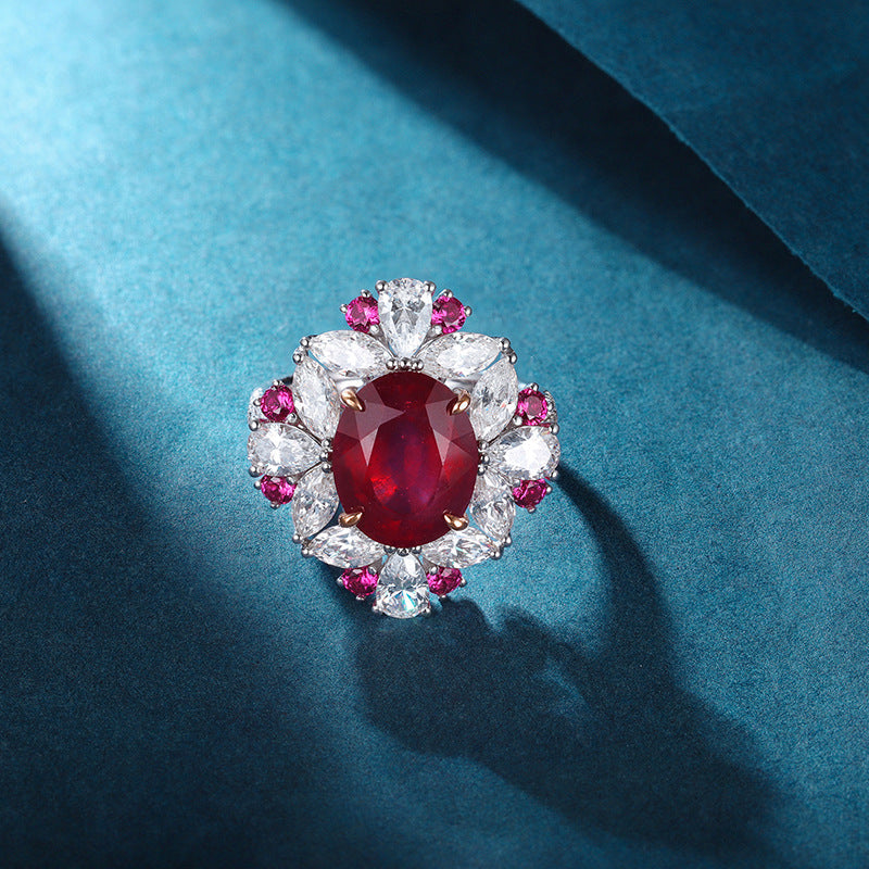 Luxurious ruby engagement ring crafted from 925 sterling silver, featuring a simulated red ruby center stone surrounded by white sapphires and pink accents.