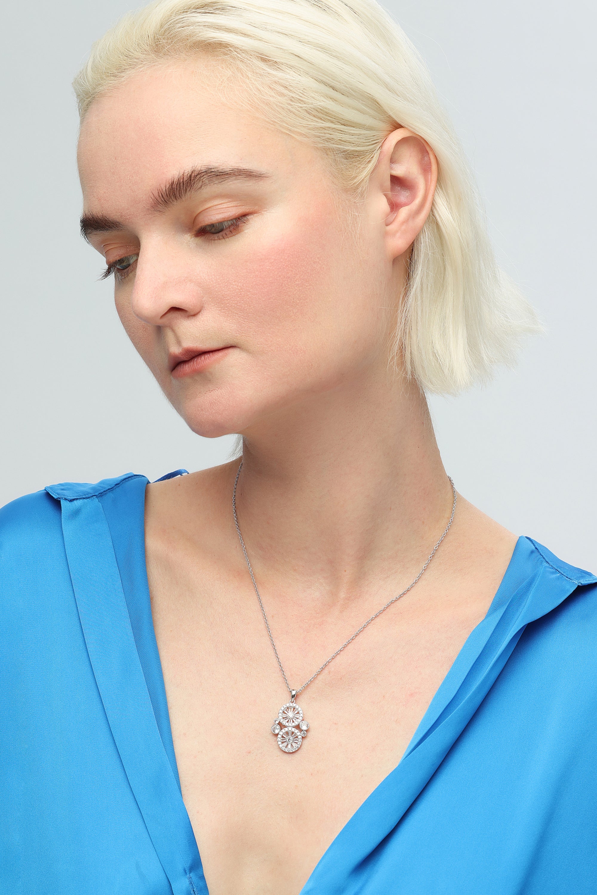 A stunning Wheel of Fortune Necklace featuring a unique wheel design adorned with sparkling pavé-set cubic zirconia, elegantly displayed on a soft background.