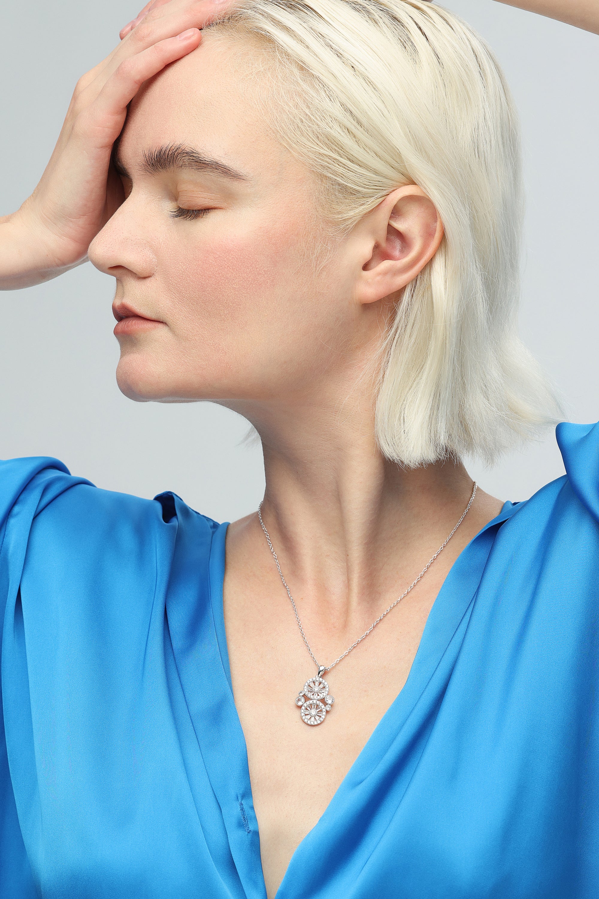 A stunning Wheel of Fortune Necklace featuring a unique wheel design adorned with sparkling pavé-set cubic zirconia, elegantly displayed on a soft background.