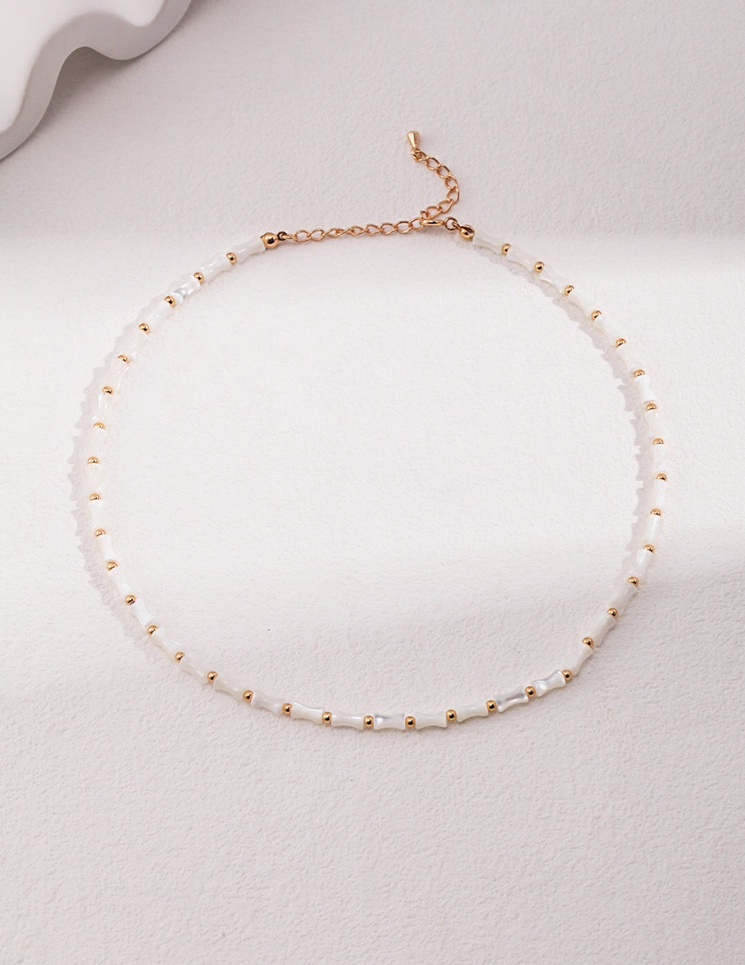 Elegant White Bamboo Choker Necklace made from Horseshoe Snail and Gold Vermeil, showcasing its delicate design and adjustable chain.