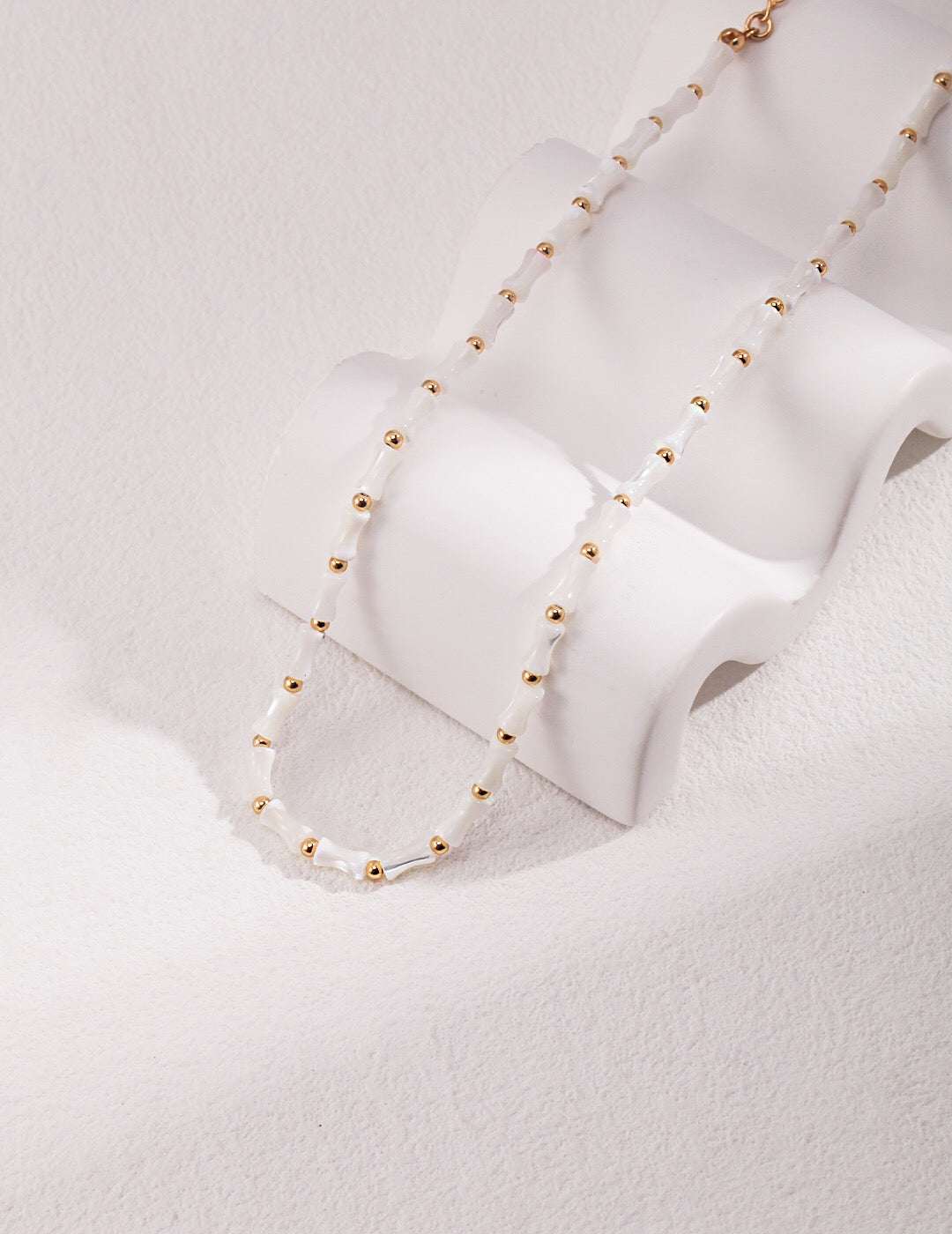 Elegant White Bamboo Choker Necklace made from Horseshoe Snail and Gold Vermeil, showcasing its delicate design and adjustable chain.