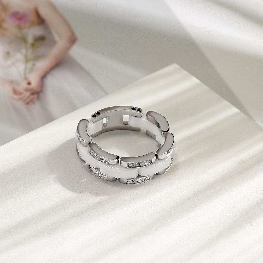 Elegant white ceramic ring with CZ stones option, displayed on a soft background.