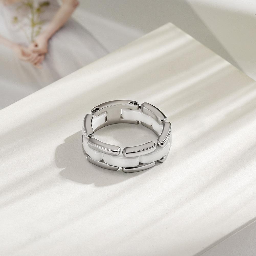 Elegant white ceramic ring with CZ stones option, displayed on a soft background.