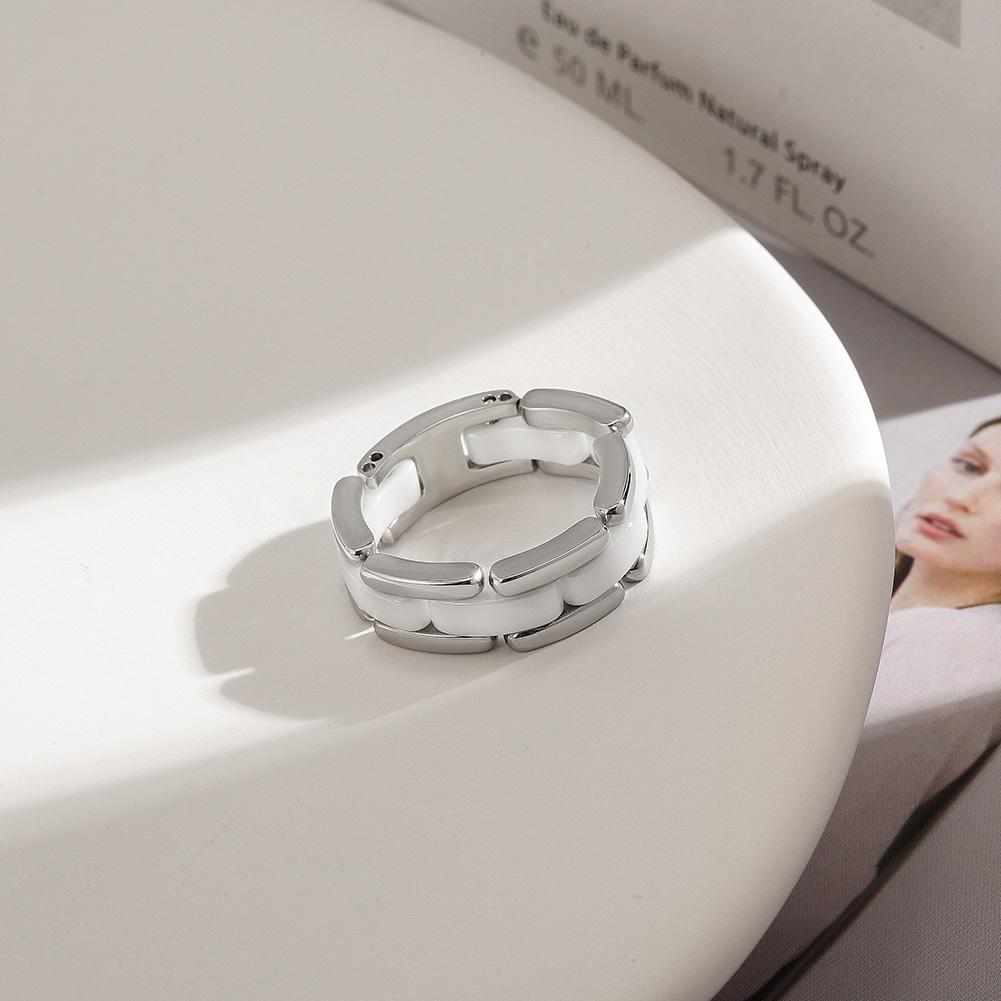 Elegant white ceramic ring with CZ stones option, displayed on a soft background.