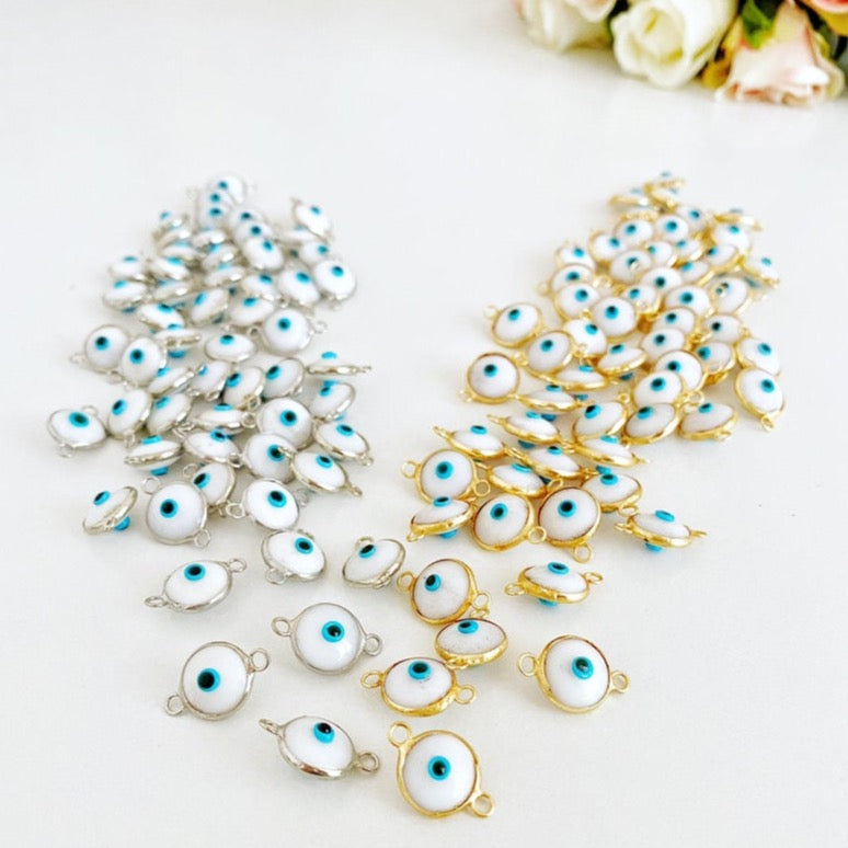 A collection of White Evil Eye Beads featuring gold and silver finishes, ideal for jewelry making.