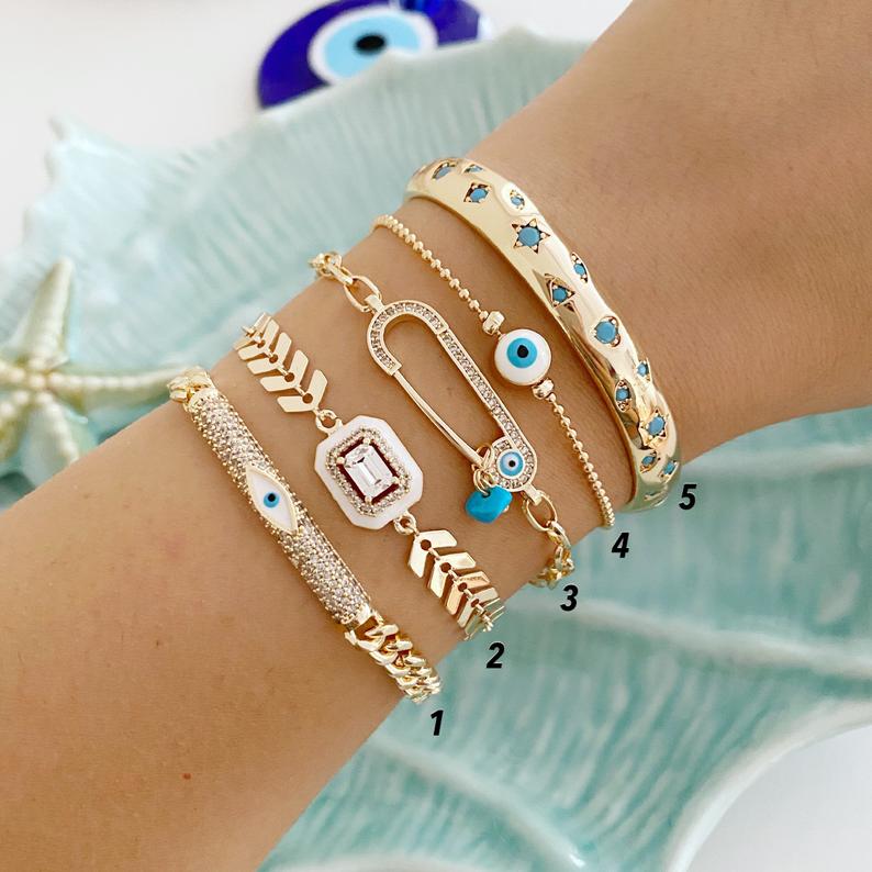 A beautiful White Evil Eye Bracelet featuring a gold bangle design, adjustable fit, and a protective evil eye charm.