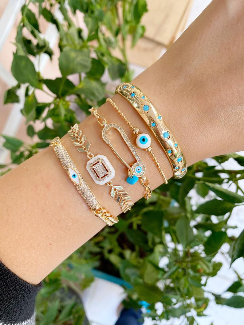 A beautiful White Evil Eye Bracelet featuring a gold bangle design, adjustable fit, and a protective evil eye charm.