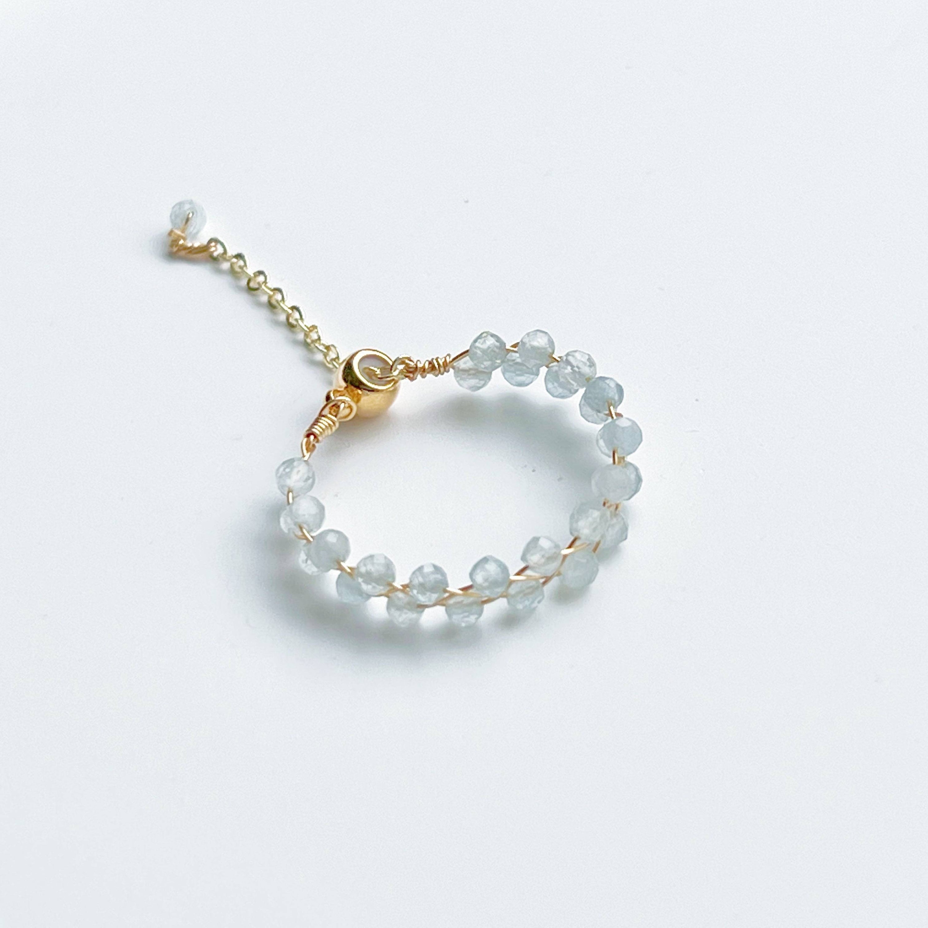 A delicate White Moonstone Beaded Ring featuring adjustable sizing and gold plated bronze wire, elegantly displayed in a gift box.