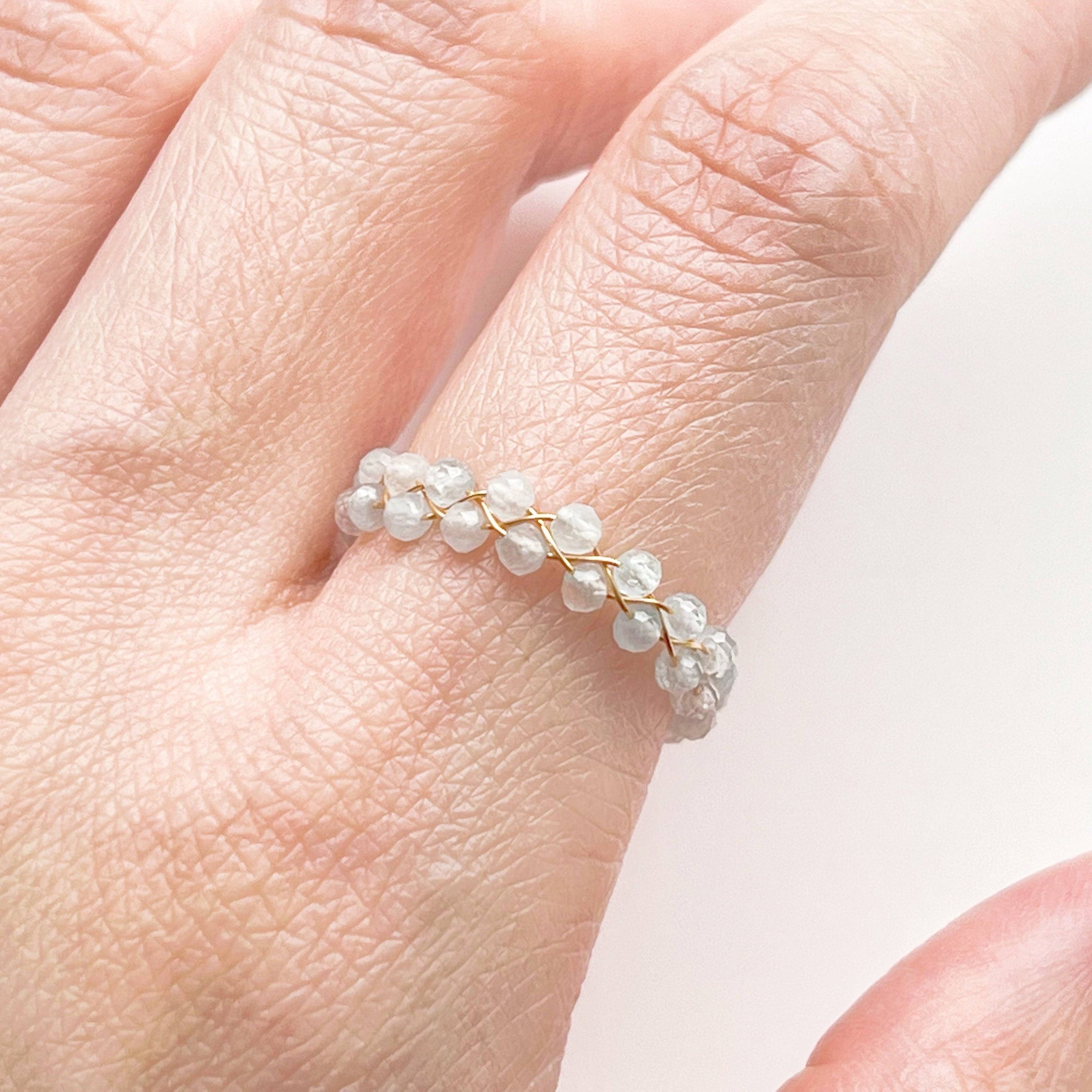 A delicate White Moonstone Beaded Ring featuring adjustable sizing and gold plated bronze wire, elegantly displayed in a gift box.