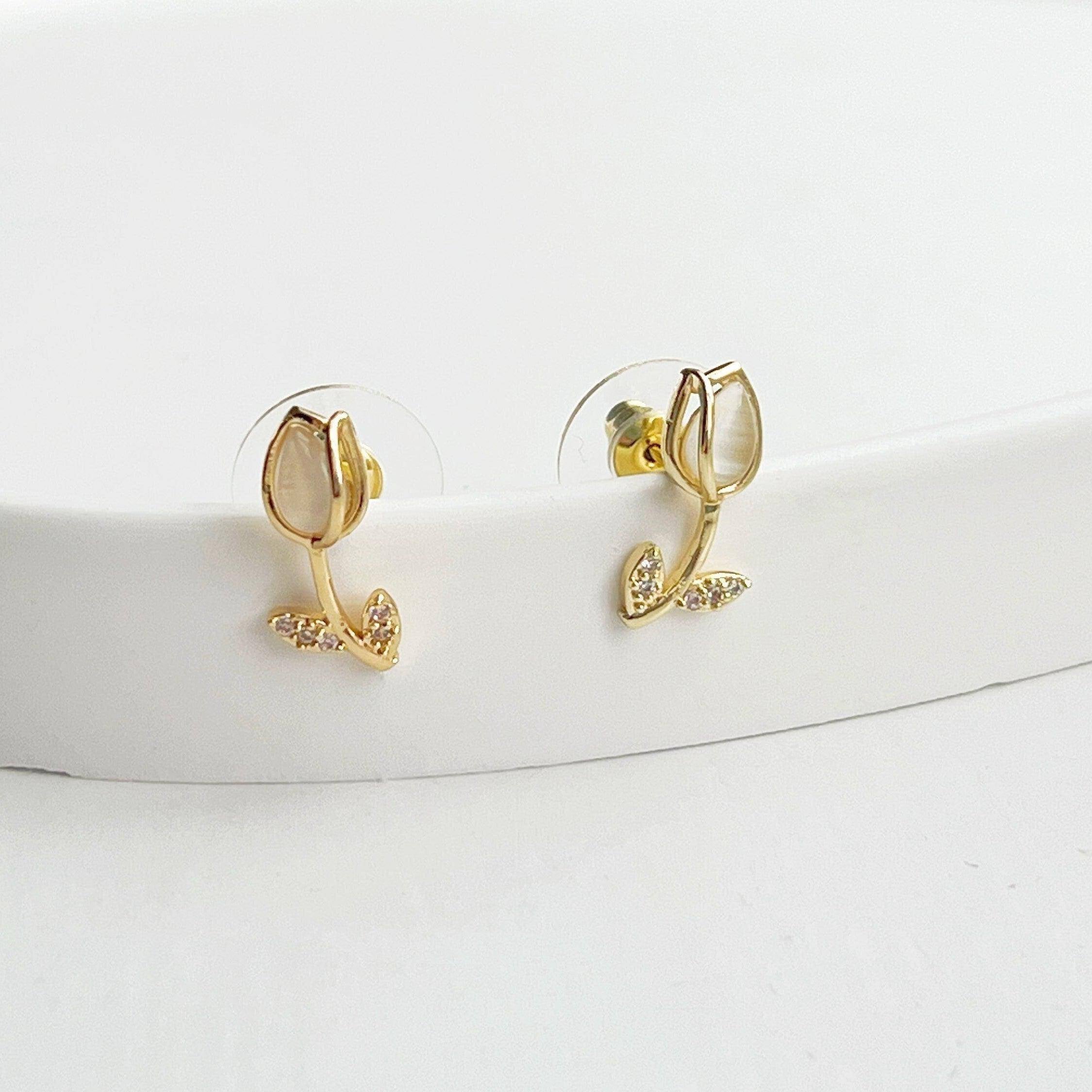 Elegant white tulip earrings featuring crystal and leaf studs, beautifully crafted in gold plated bronze and sterling silver.