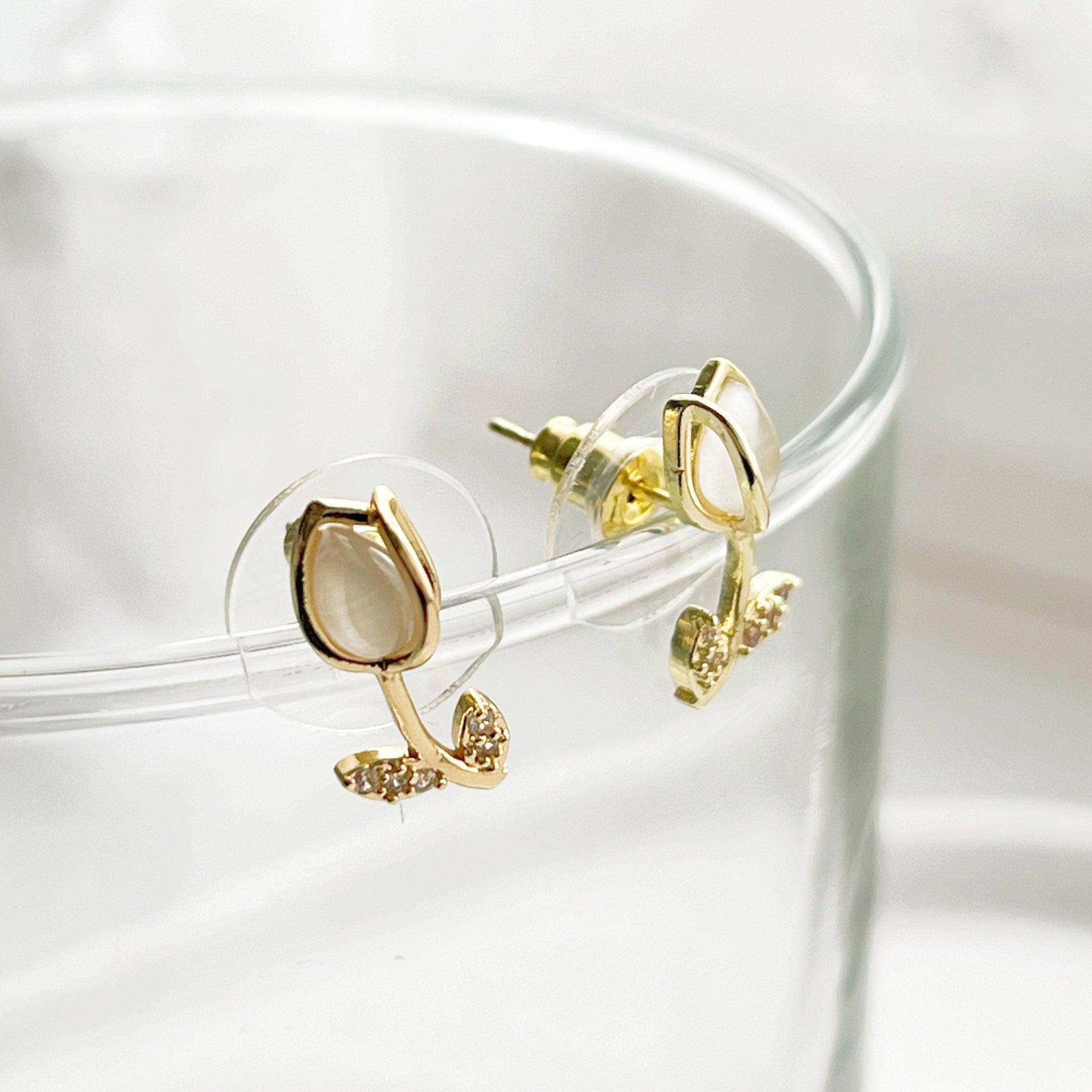 Elegant white tulip earrings featuring crystal and leaf studs, beautifully crafted in gold plated bronze and sterling silver.