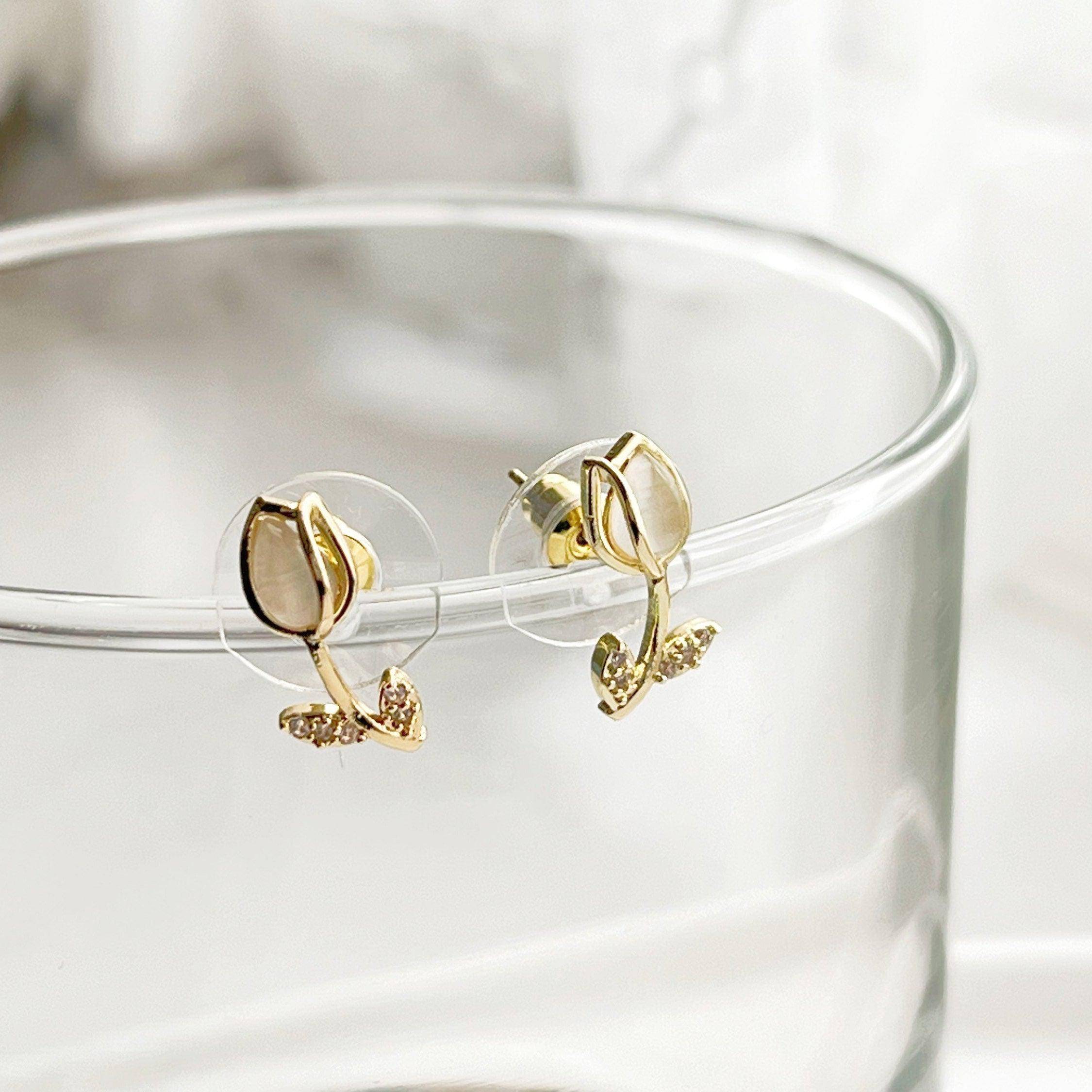 Elegant white tulip earrings featuring crystal and leaf studs, beautifully crafted in gold plated bronze and sterling silver.