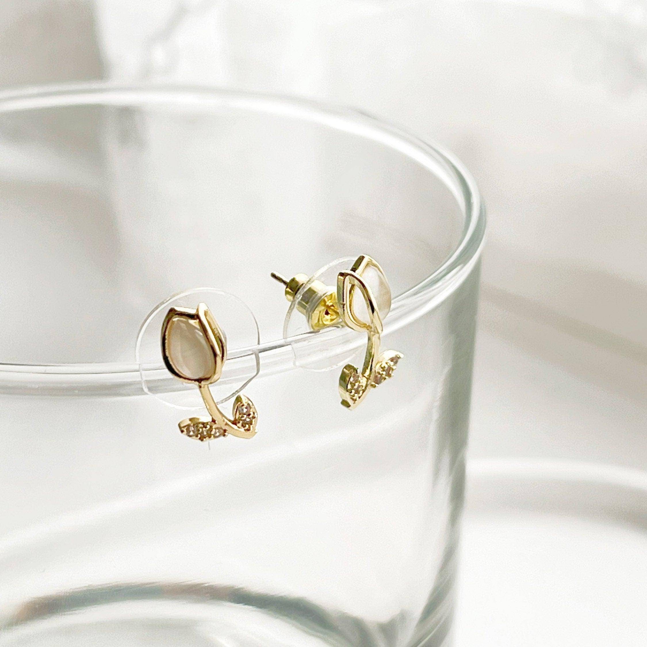 Elegant white tulip earrings featuring crystal and leaf studs, beautifully crafted in gold plated bronze and sterling silver.