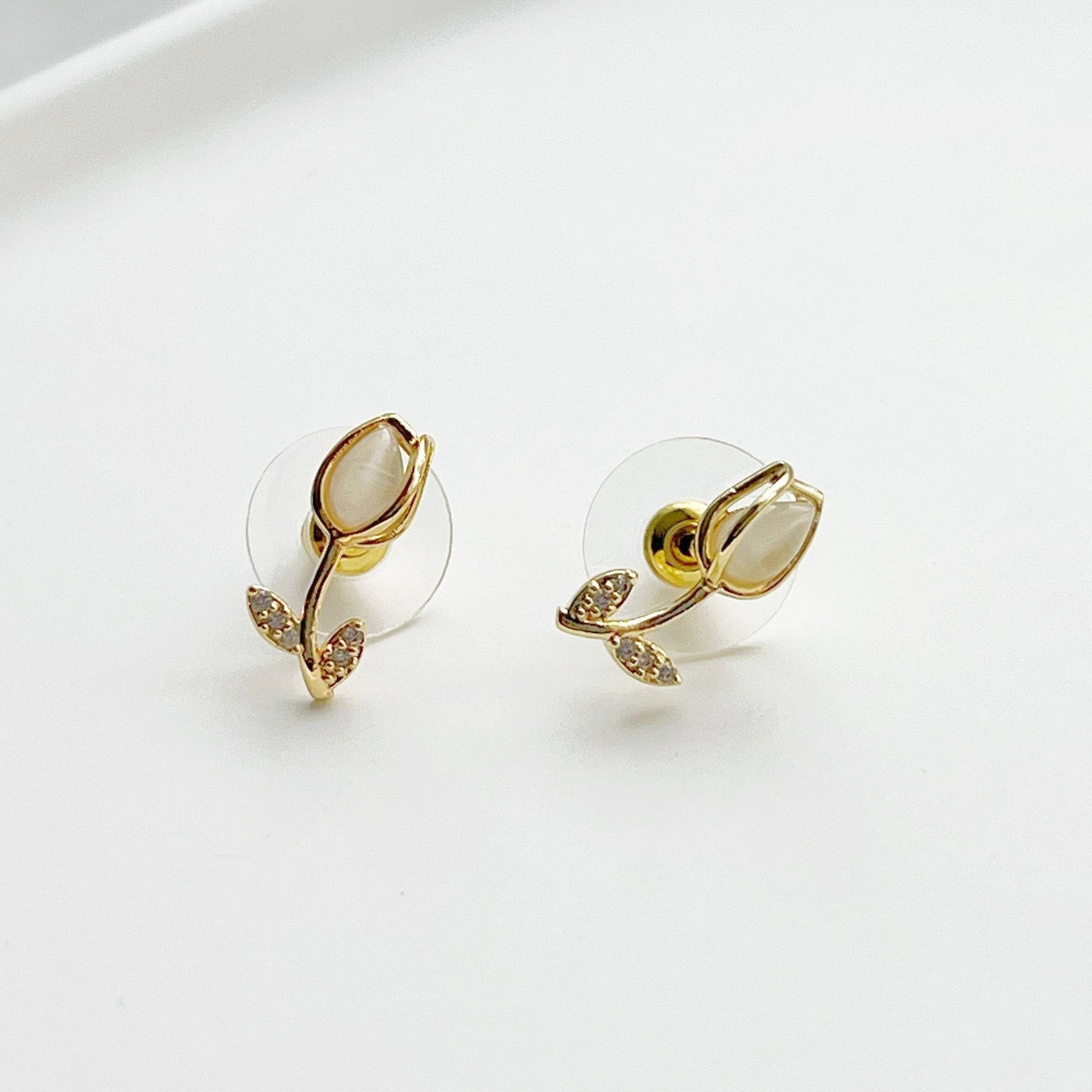 Elegant white tulip earrings featuring crystal and leaf studs, beautifully crafted in gold plated bronze and sterling silver.