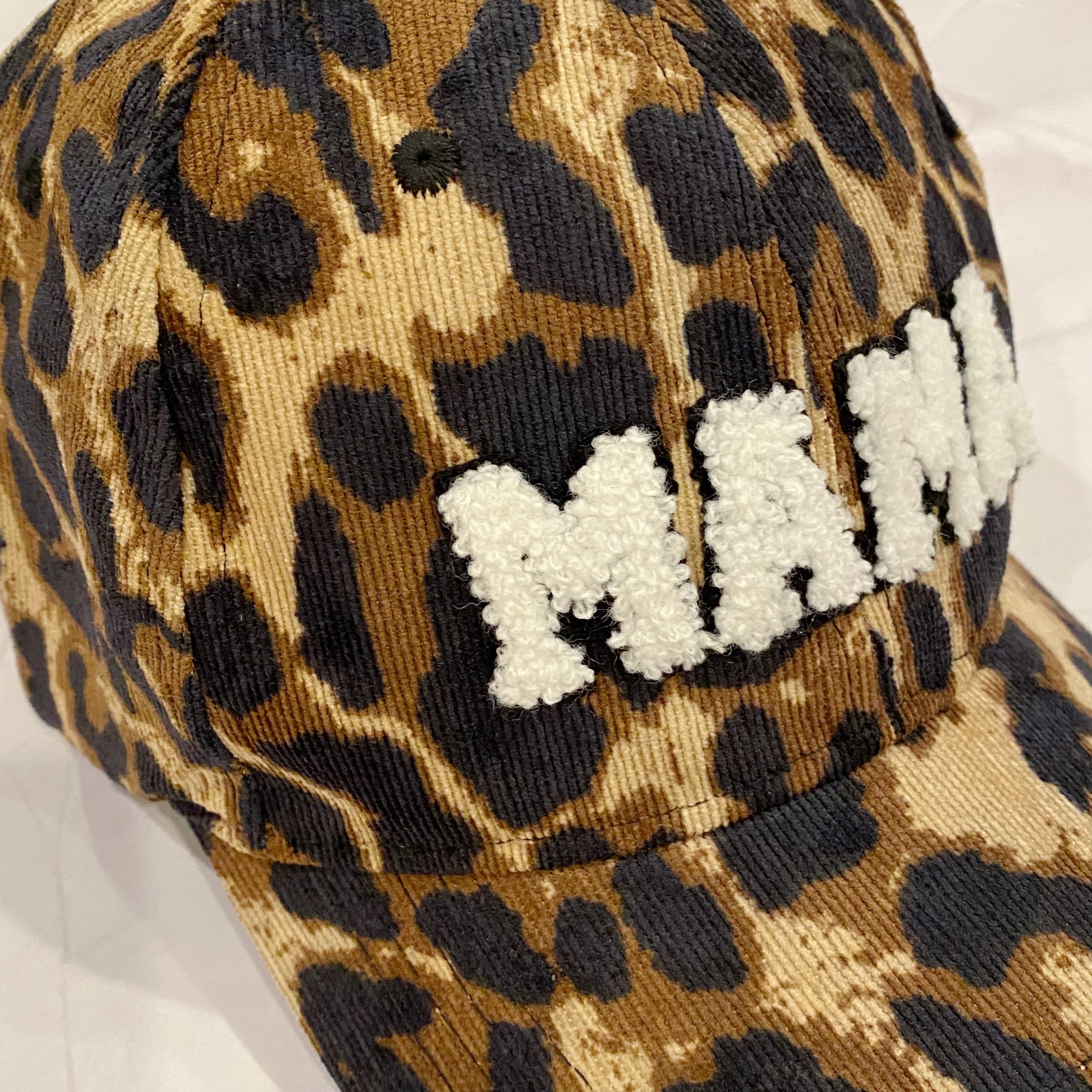 Wild Mama Corduroy Ball Cap featuring playful animal print and fuzzy lettering, adjustable strap, and hidden pocket for a sleek look.