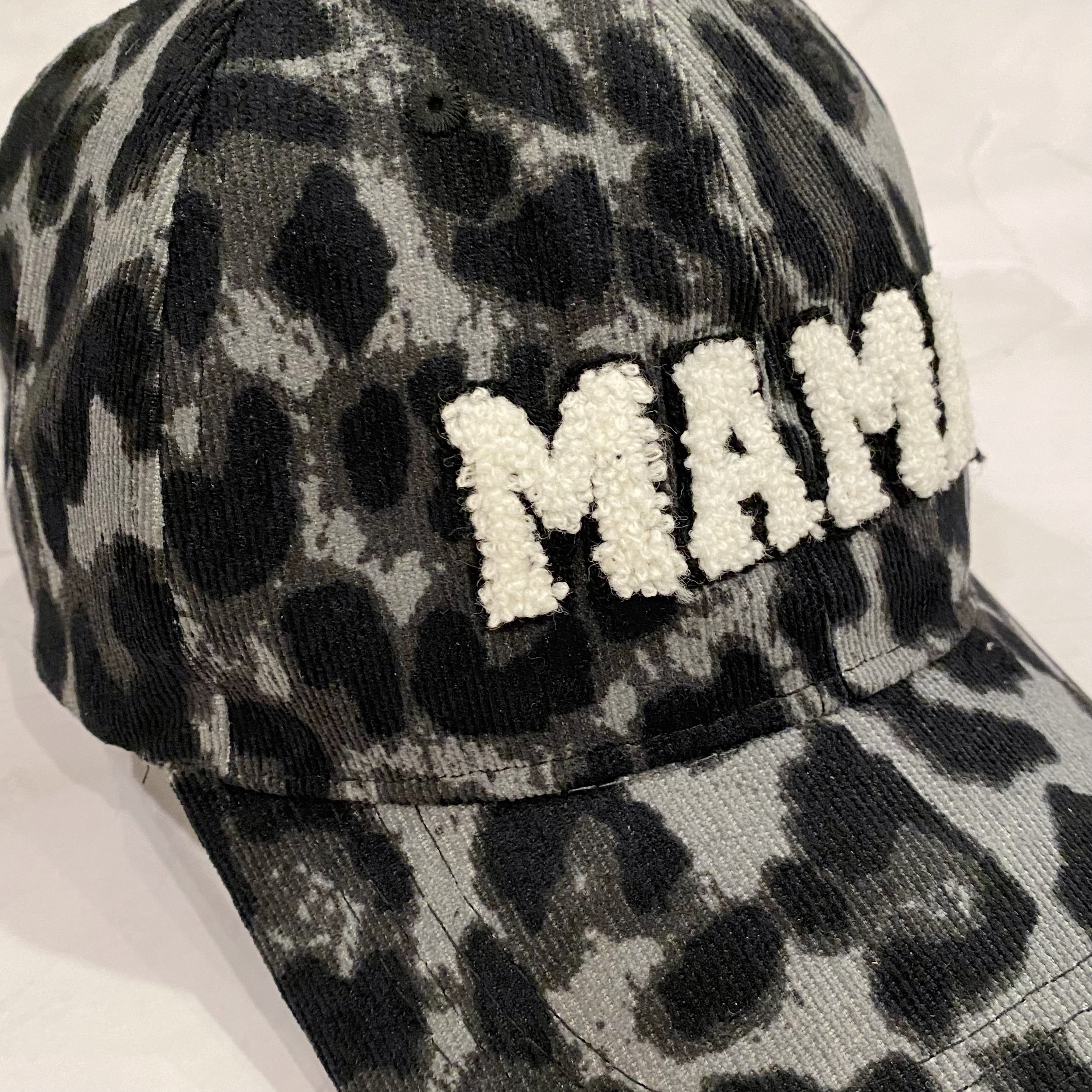 Wild Mama Corduroy Ball Cap featuring playful animal print and fuzzy lettering, adjustable strap, and hidden pocket for a sleek look.