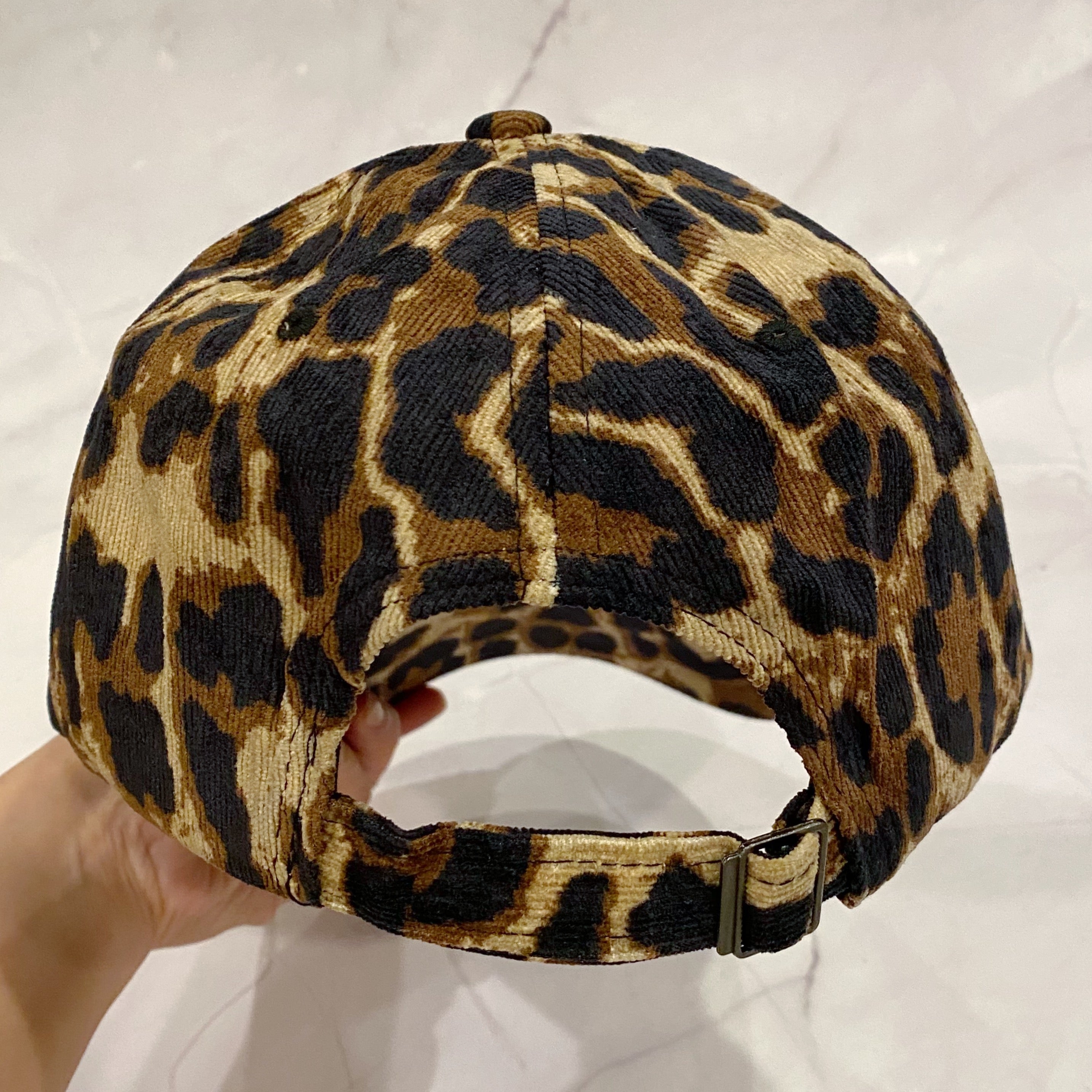 Wild Mama Corduroy Ball Cap featuring playful animal print and fuzzy lettering, adjustable strap, and hidden pocket for a sleek look.