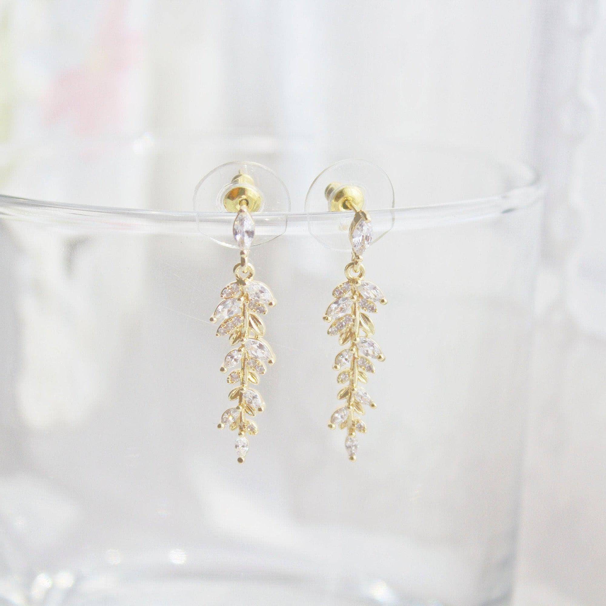 Elegant gold and crystal leaf dangle drop earrings, showcasing a beautiful design that embodies grace and sophistication.