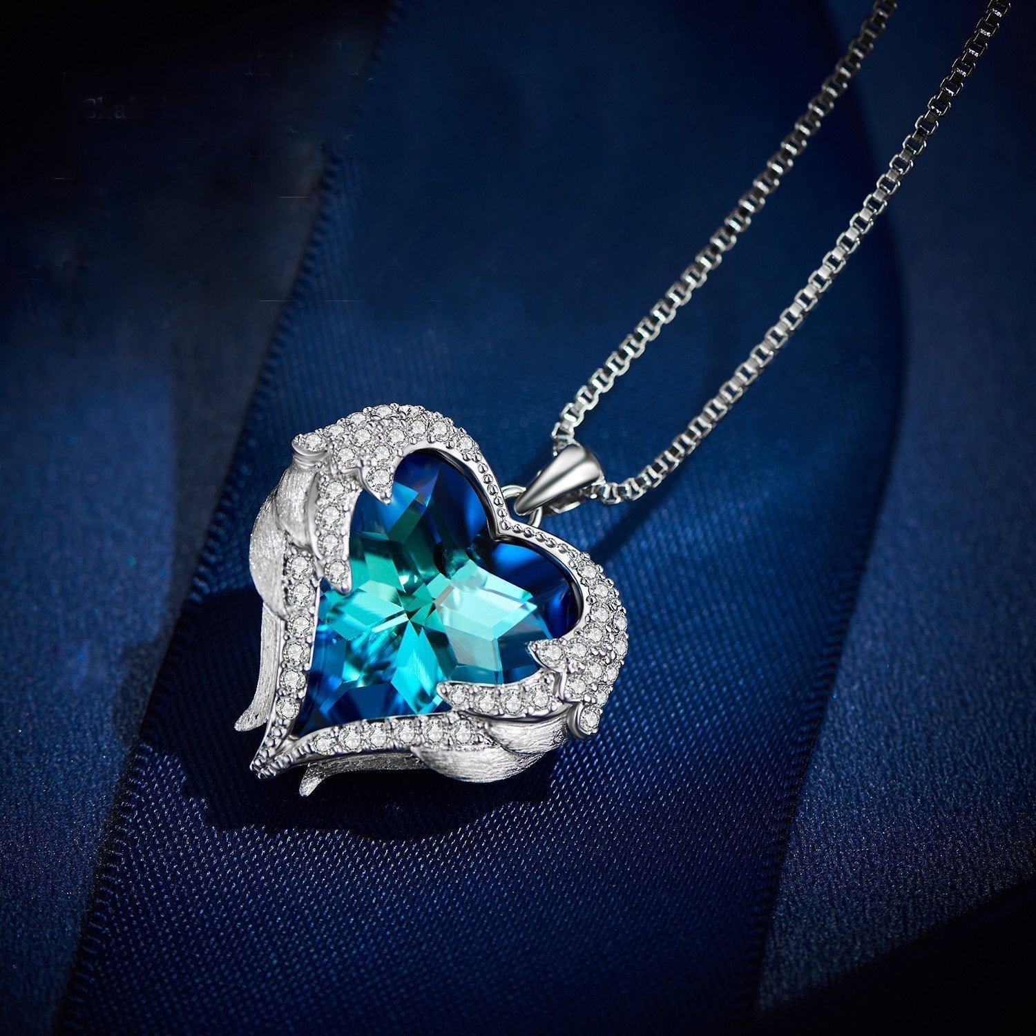 Wings of an Angel Heart Blue Topaz Necklace and Earring Set featuring 18K white gold plating and Austrian crystals, elegantly displayed.