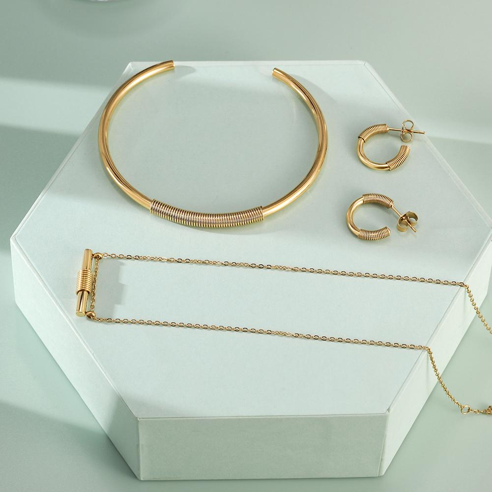 Wire Set featuring a mini bar necklace, tiny hoop earrings, and a cuff bangle in 14k gold over stainless steel, elegantly displayed in a gift box.