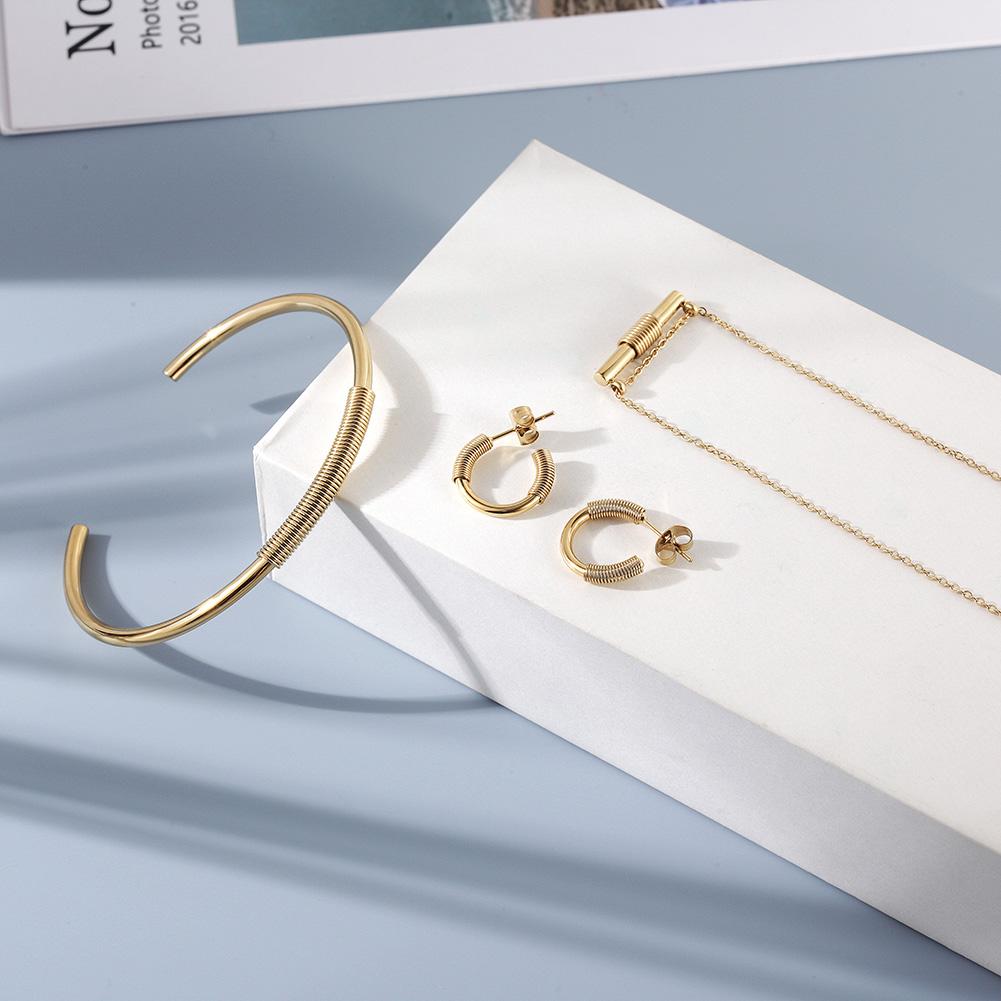 Wire Set featuring a mini bar necklace, tiny hoop earrings, and a cuff bangle in 14k gold over stainless steel, elegantly displayed in a gift box.