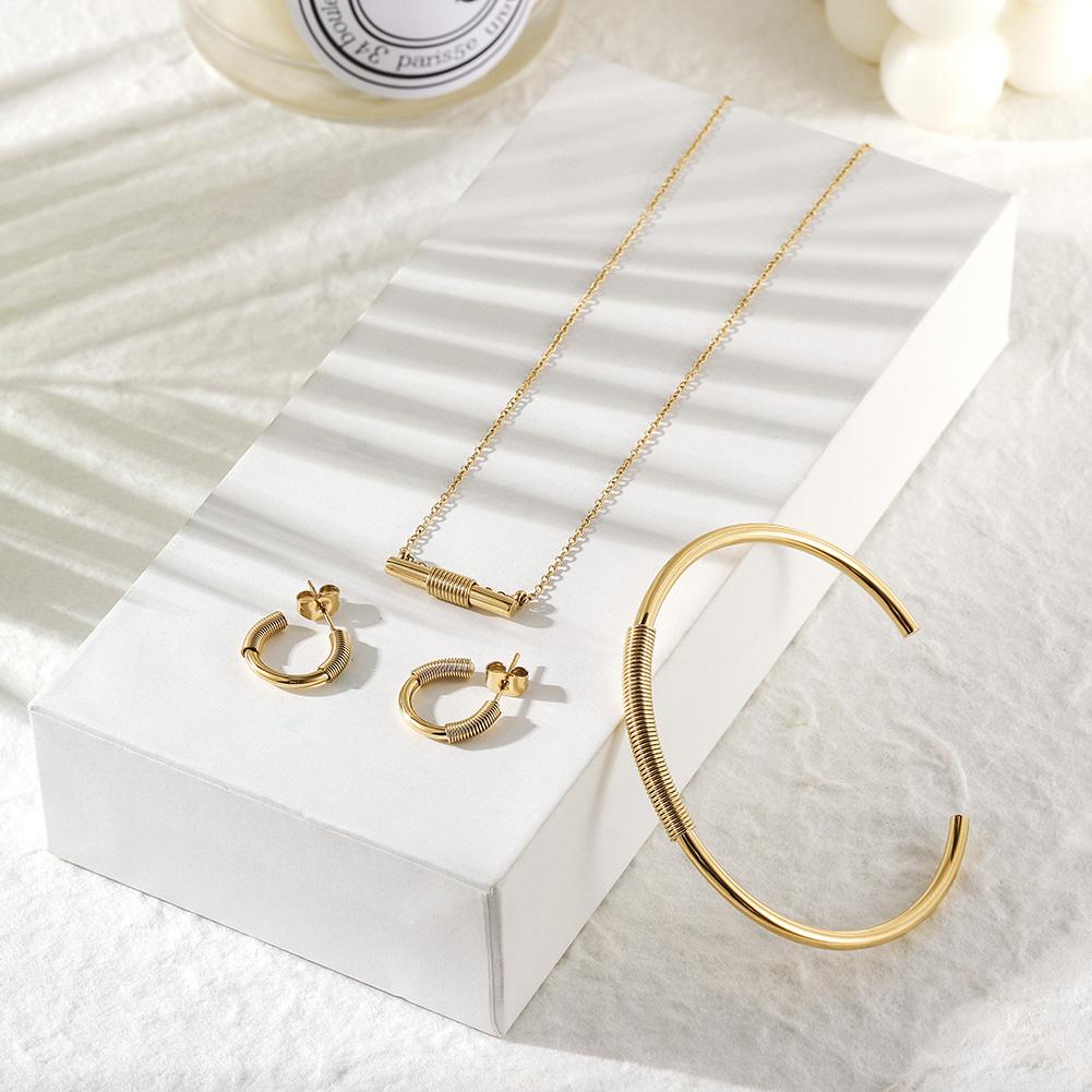 Wire Set featuring a mini bar necklace, tiny hoop earrings, and a cuff bangle in 14k gold over stainless steel, elegantly displayed in a gift box.